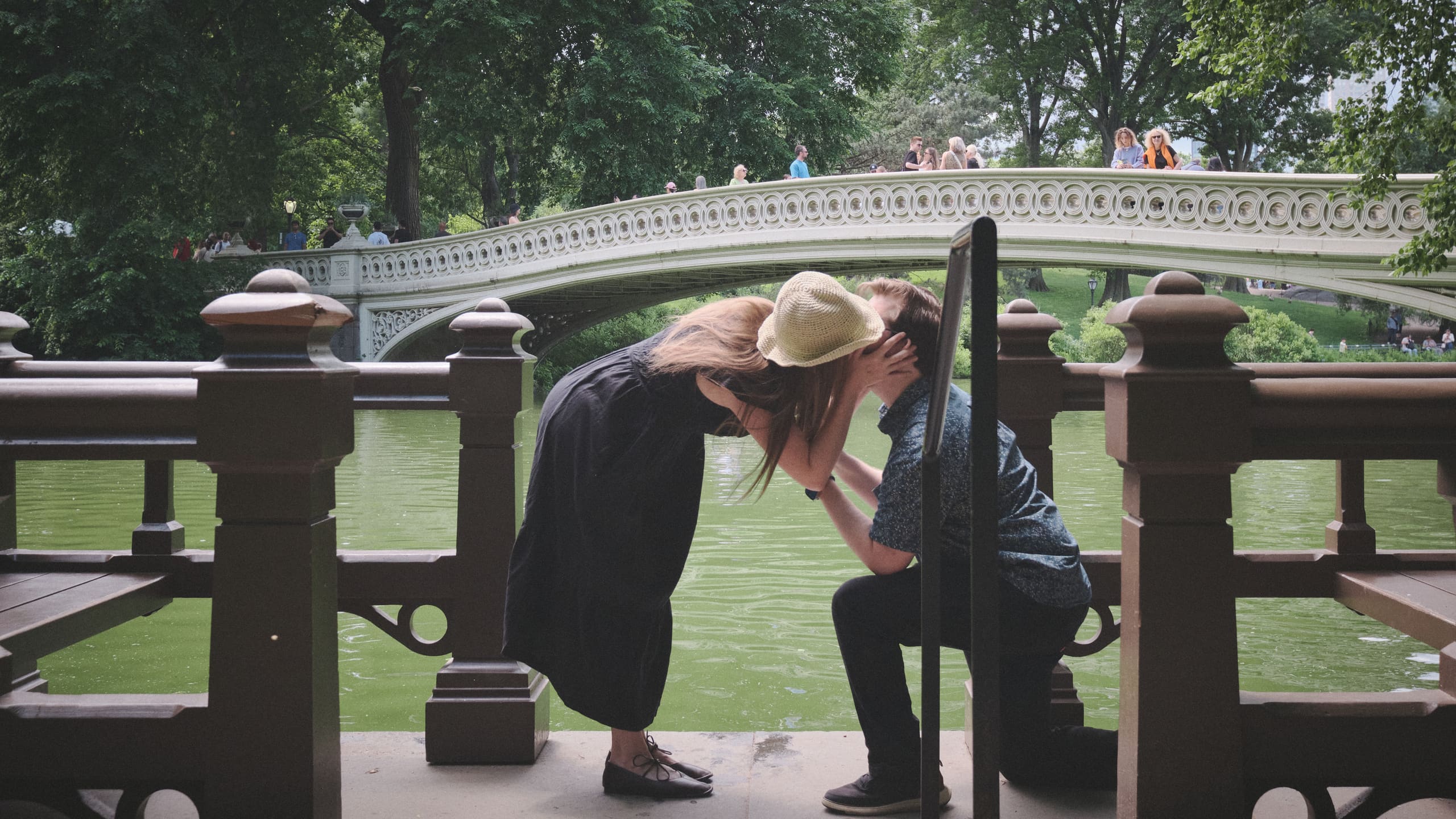 The moment after she said yes, mid-leap beside the bridge railing