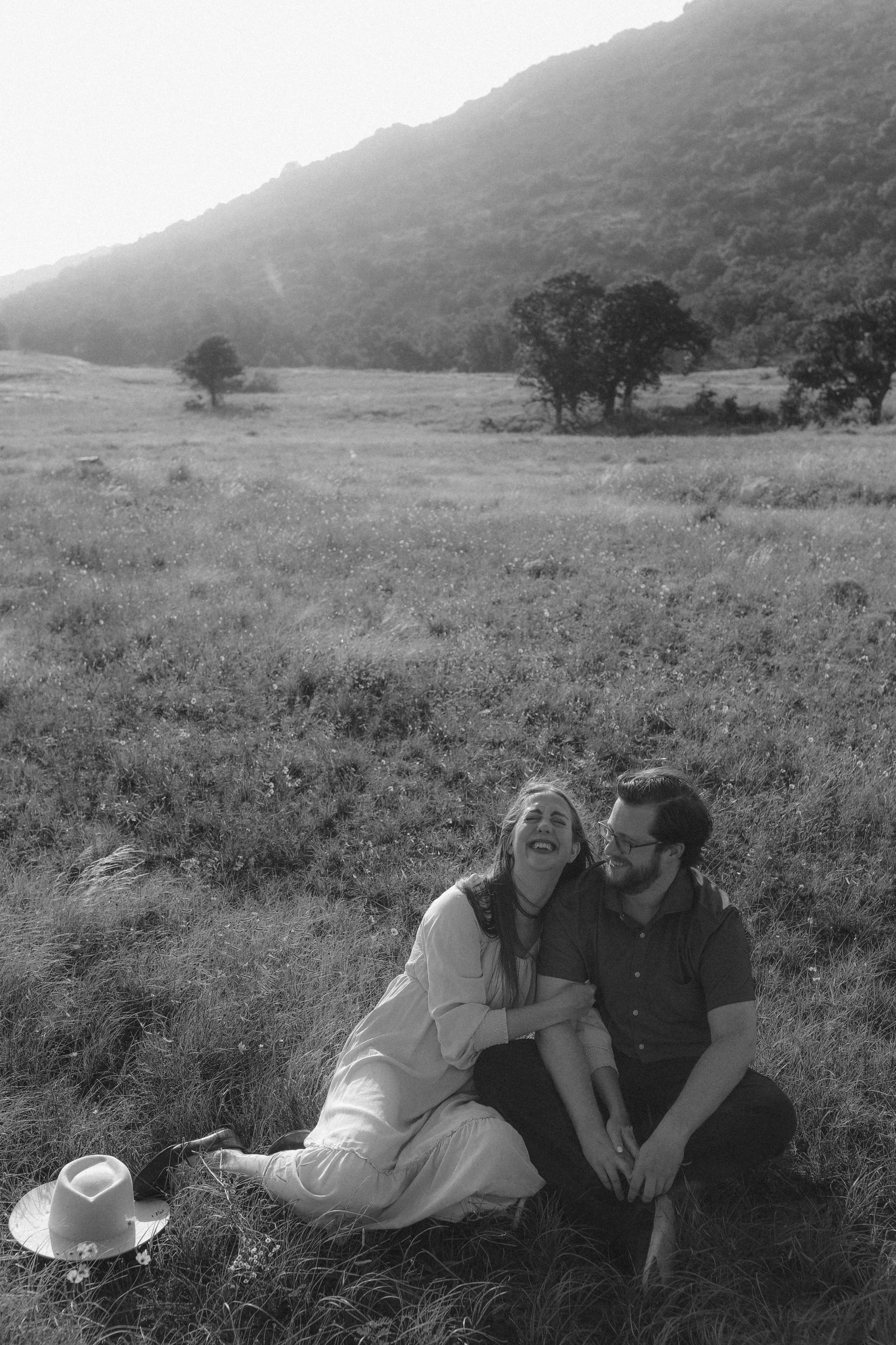 Laughing in the meadow below the mountain, her hat set in the grass