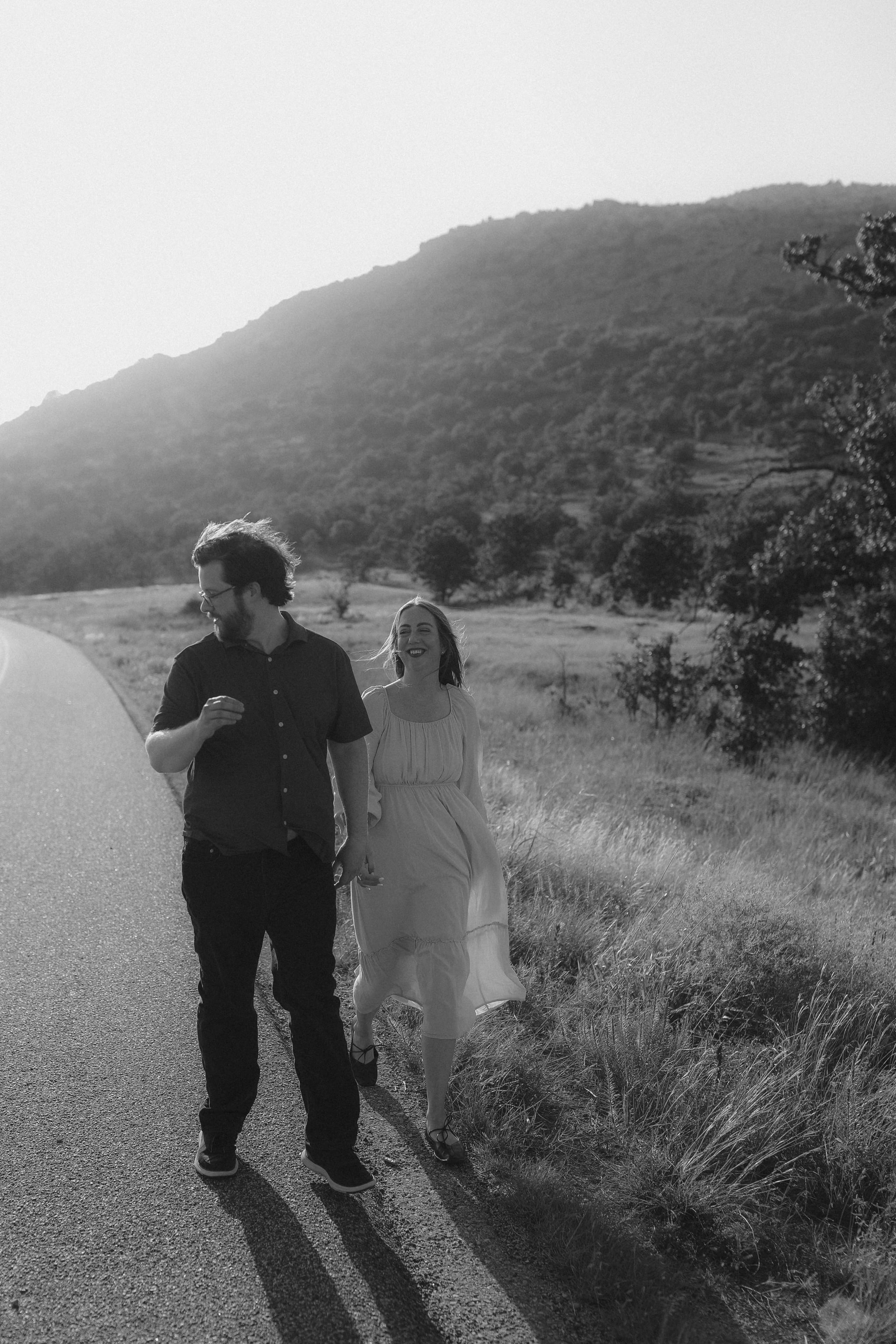 Laughing down the road together, the mountain hazy behind them