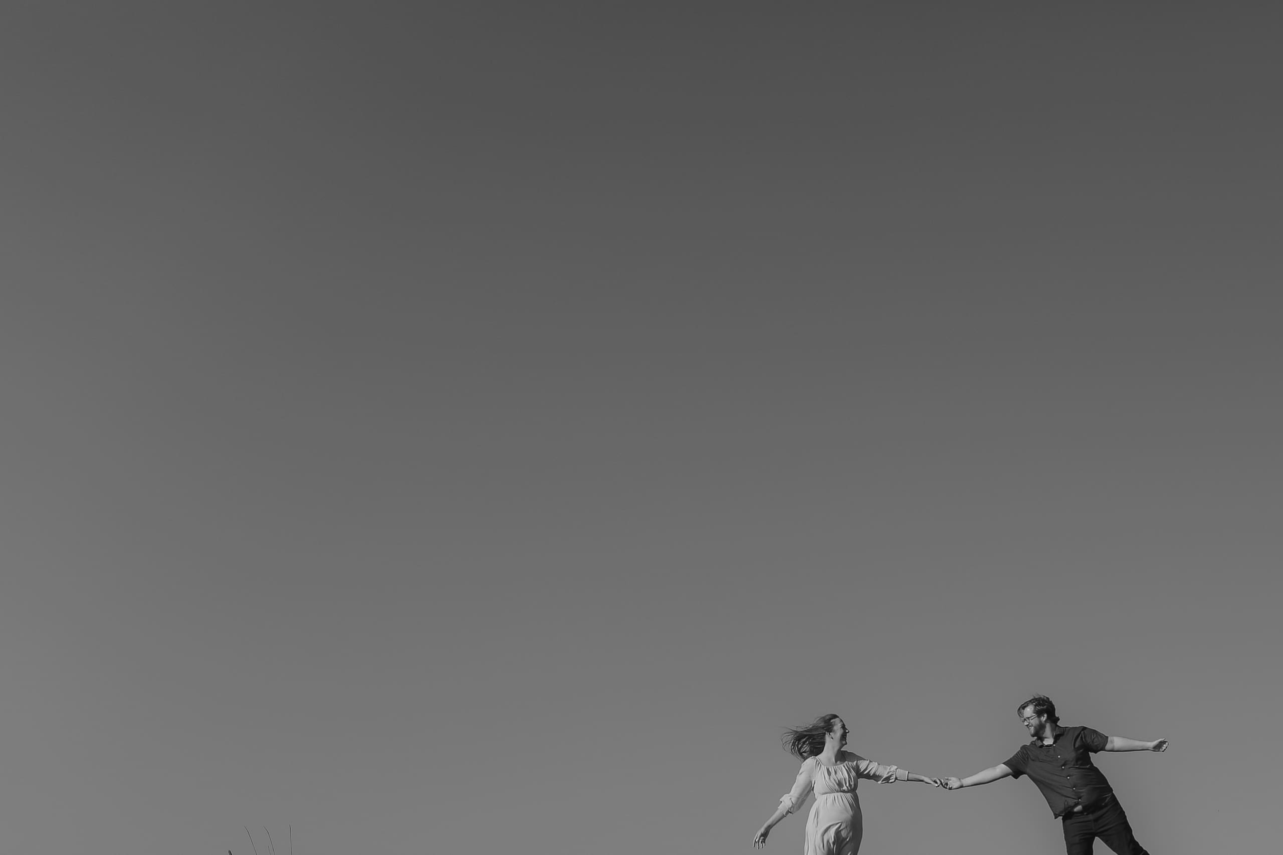 Fingertips just touching against a wide open sky