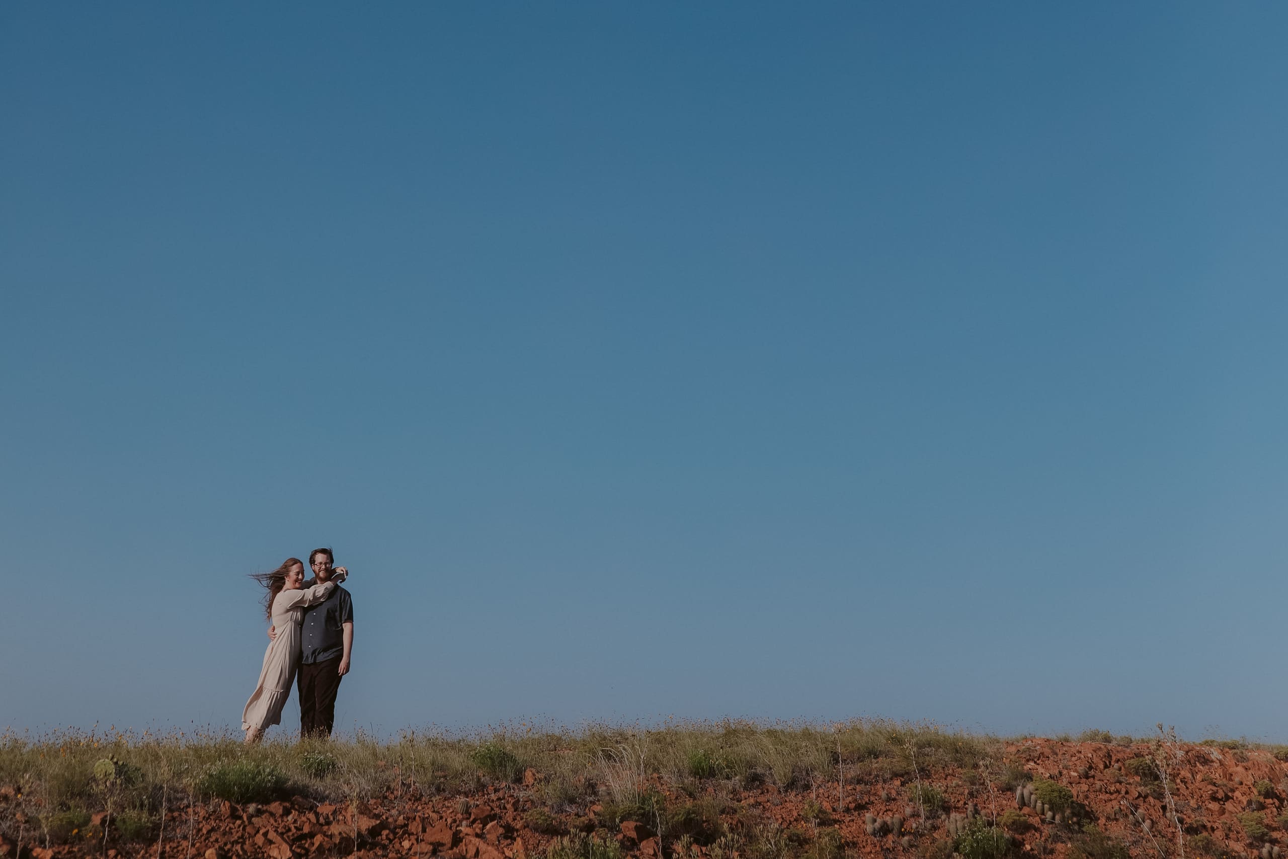 Wrapped up together on a rocky rise beneath an open blue sky