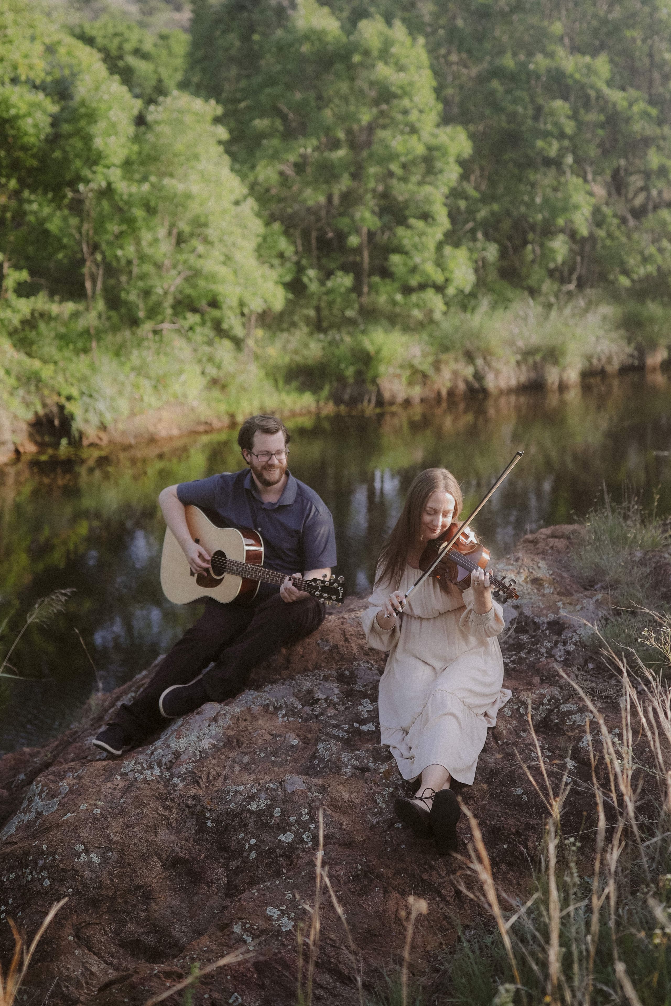 Music by the creek — he strums while she plays the violin