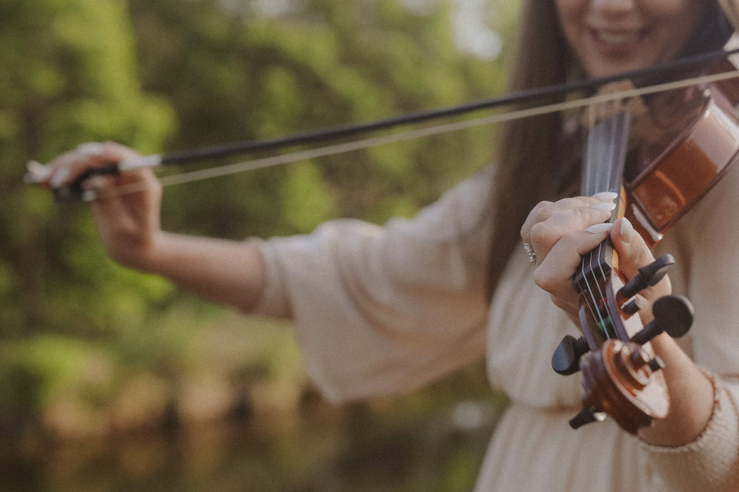 A close-up of the violin mid-song, bow drawn across the strings