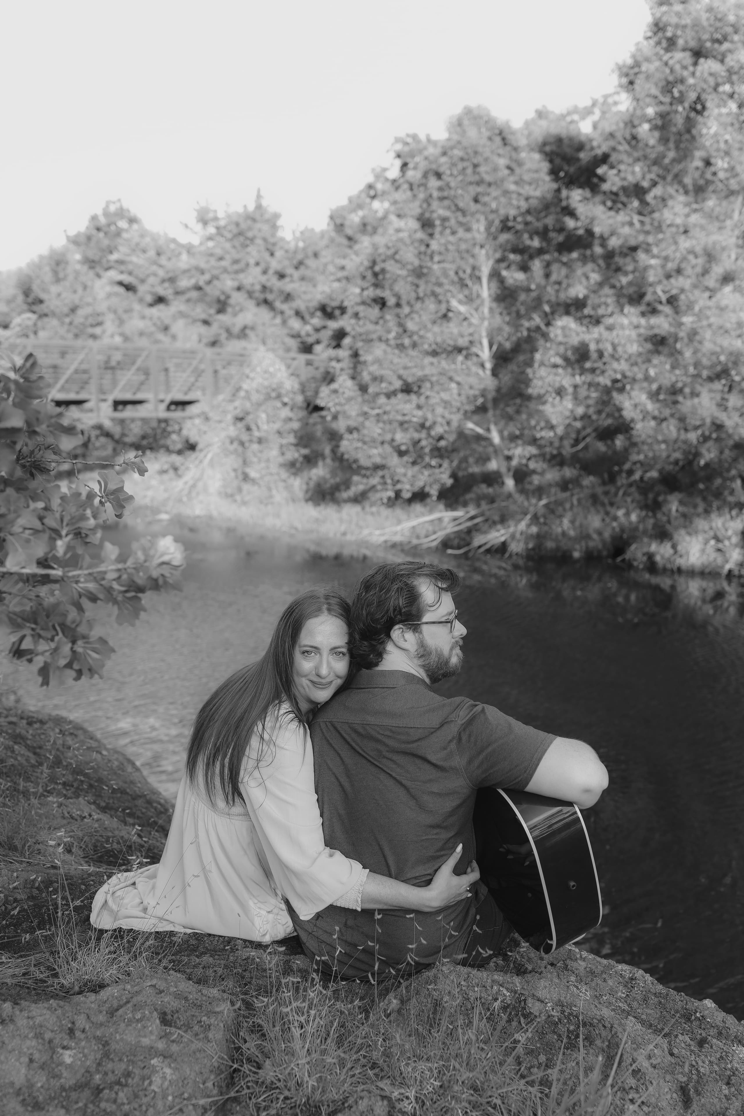 She smiles over his shoulder in black and white, arms wrapped around him