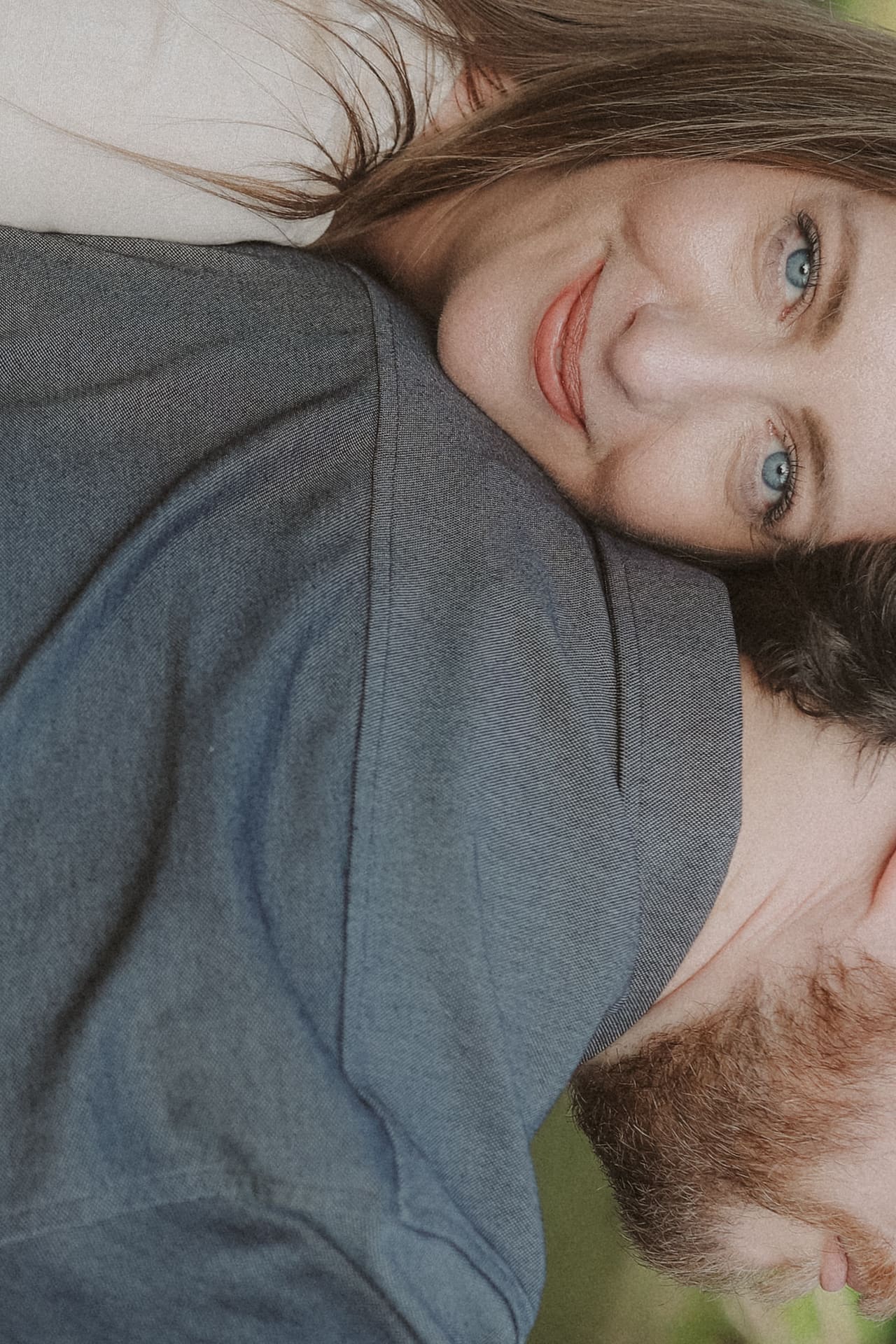 A close embrace — her smile resting against his shoulder