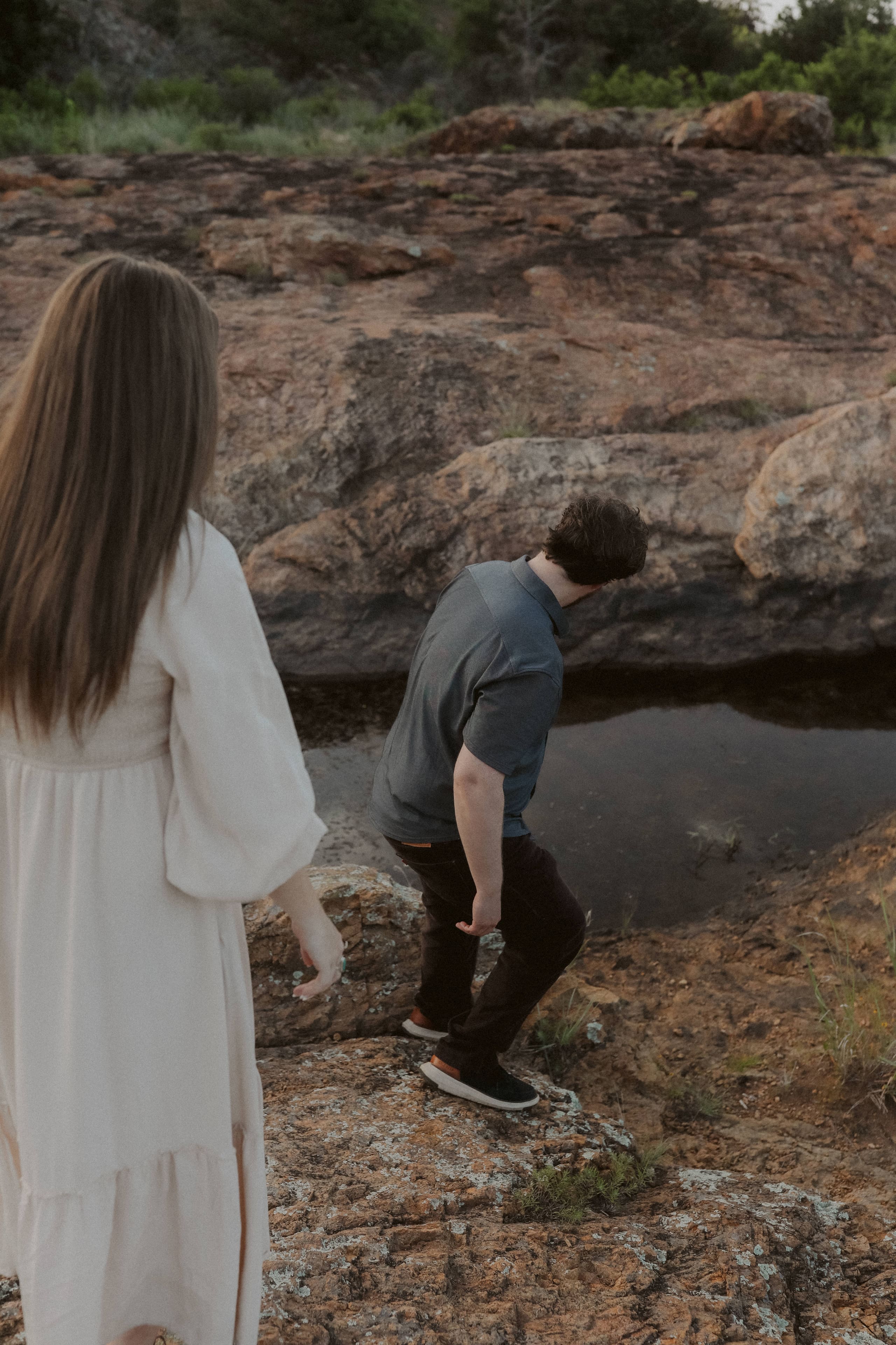 Stepping down the granite toward a still pool, her following close behind