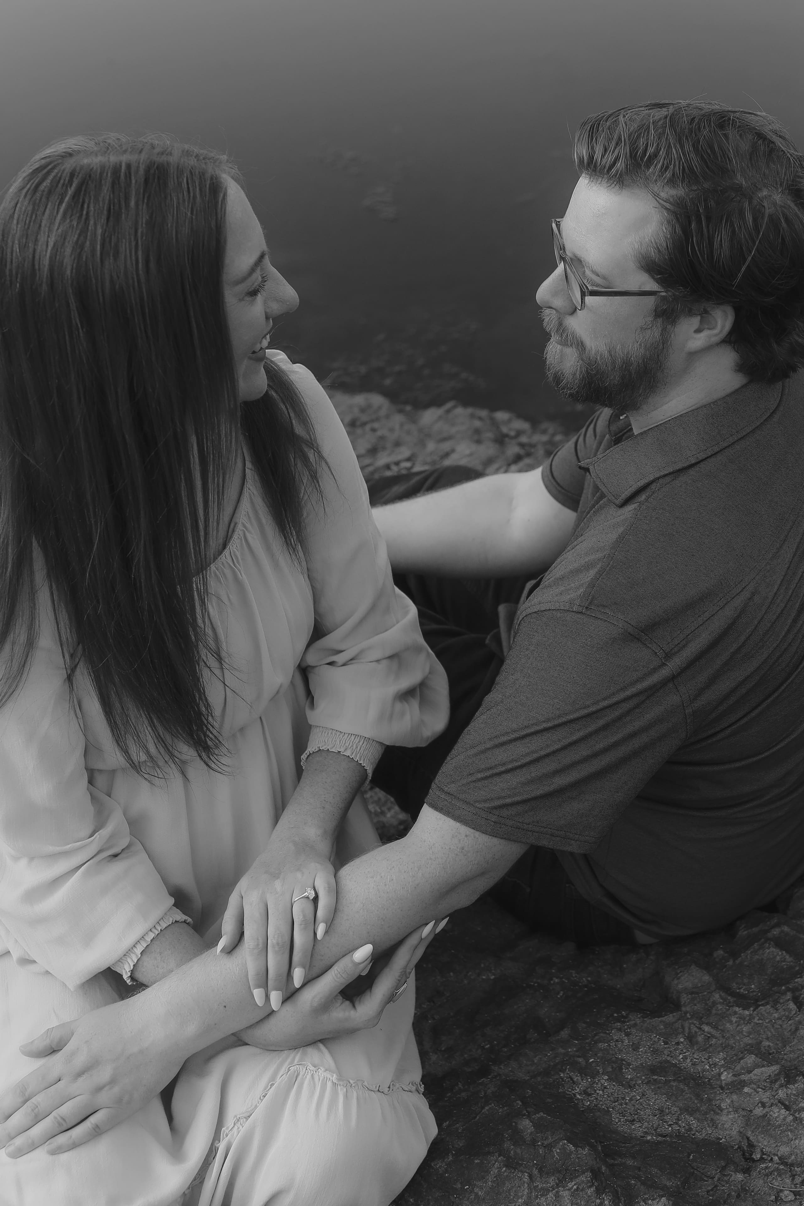 Her ring in view as they sit close at the water’s edge