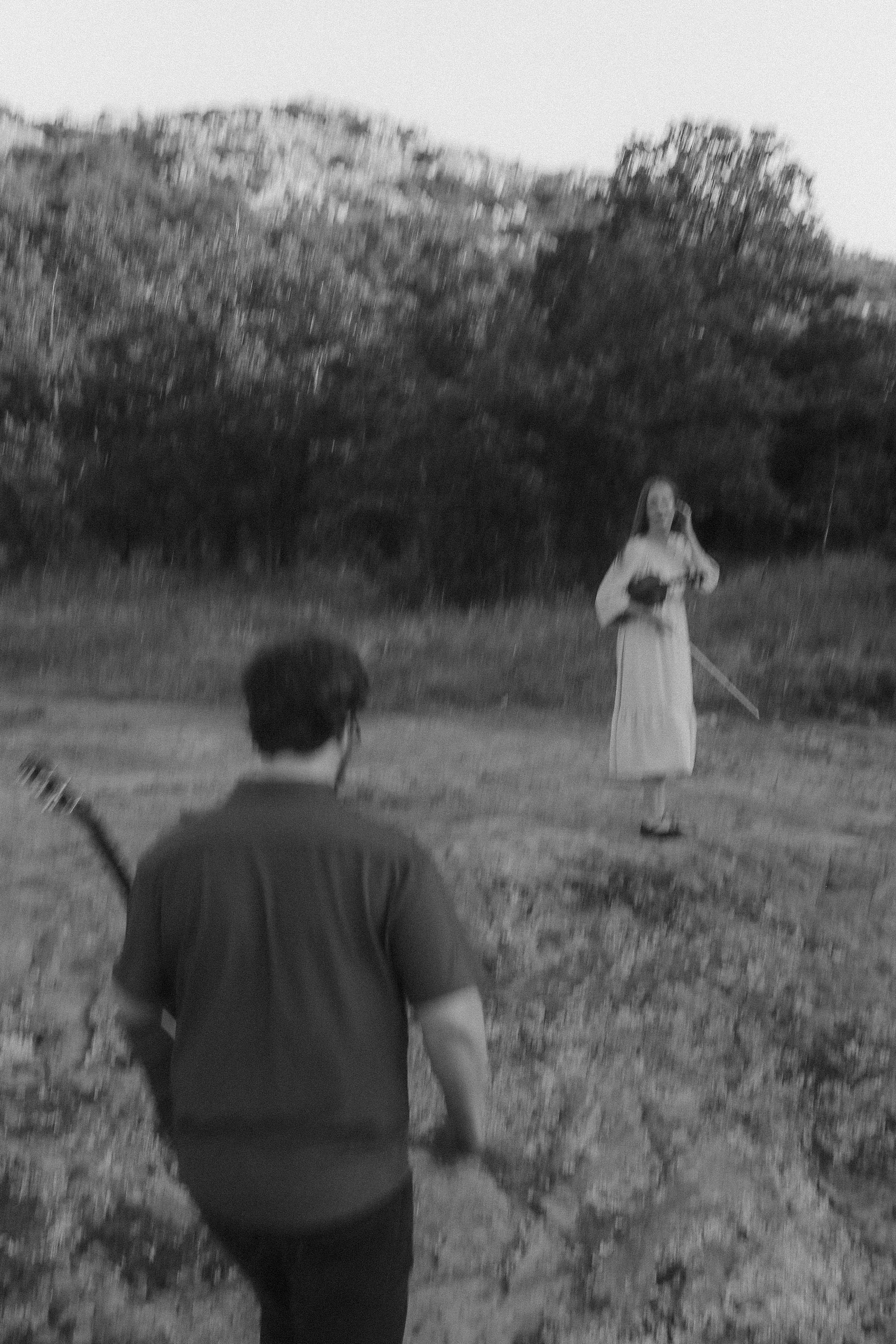 He walks toward her across the field, violin resting at her shoulder