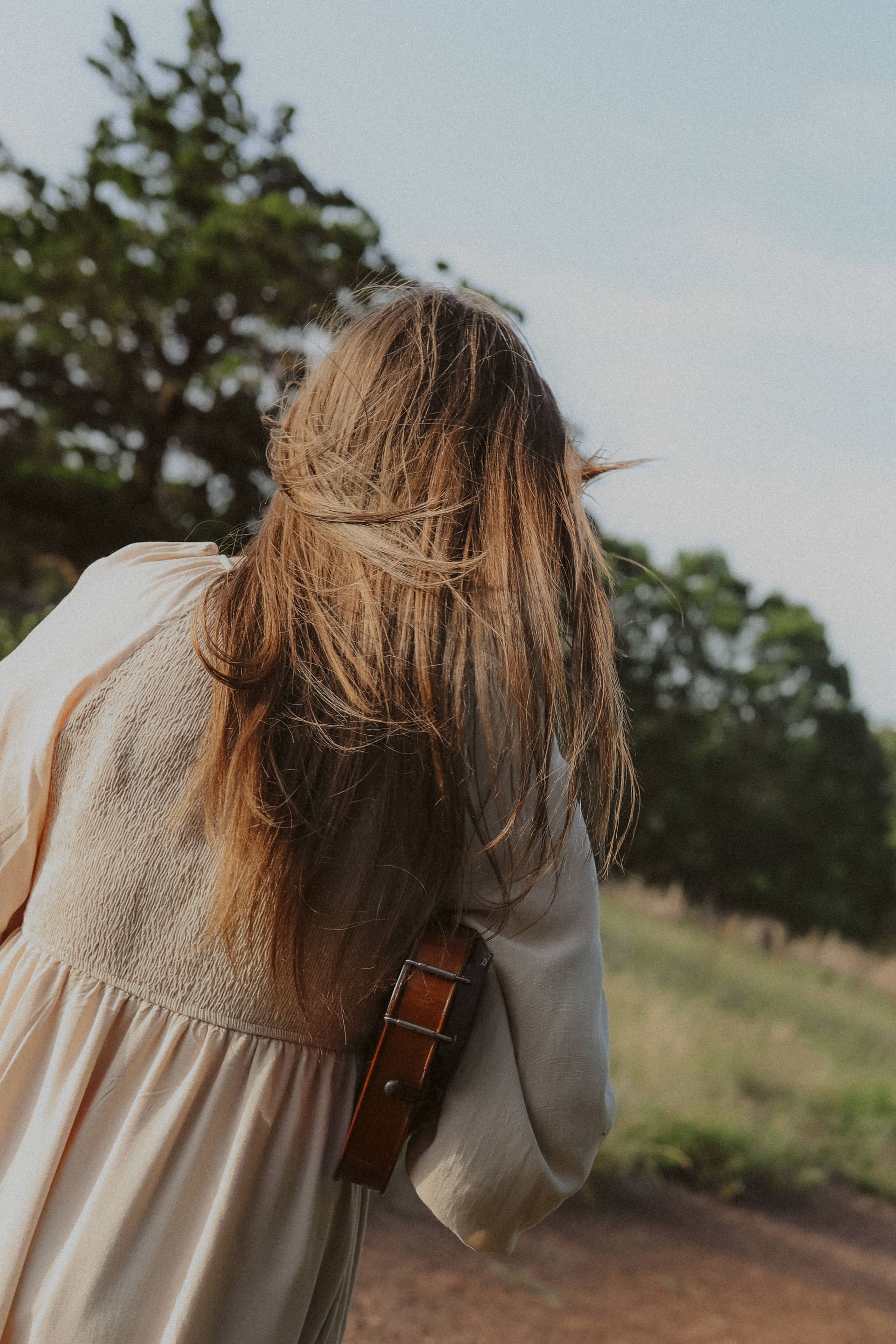 Her hair loose in the wind, violin tucked under her arm