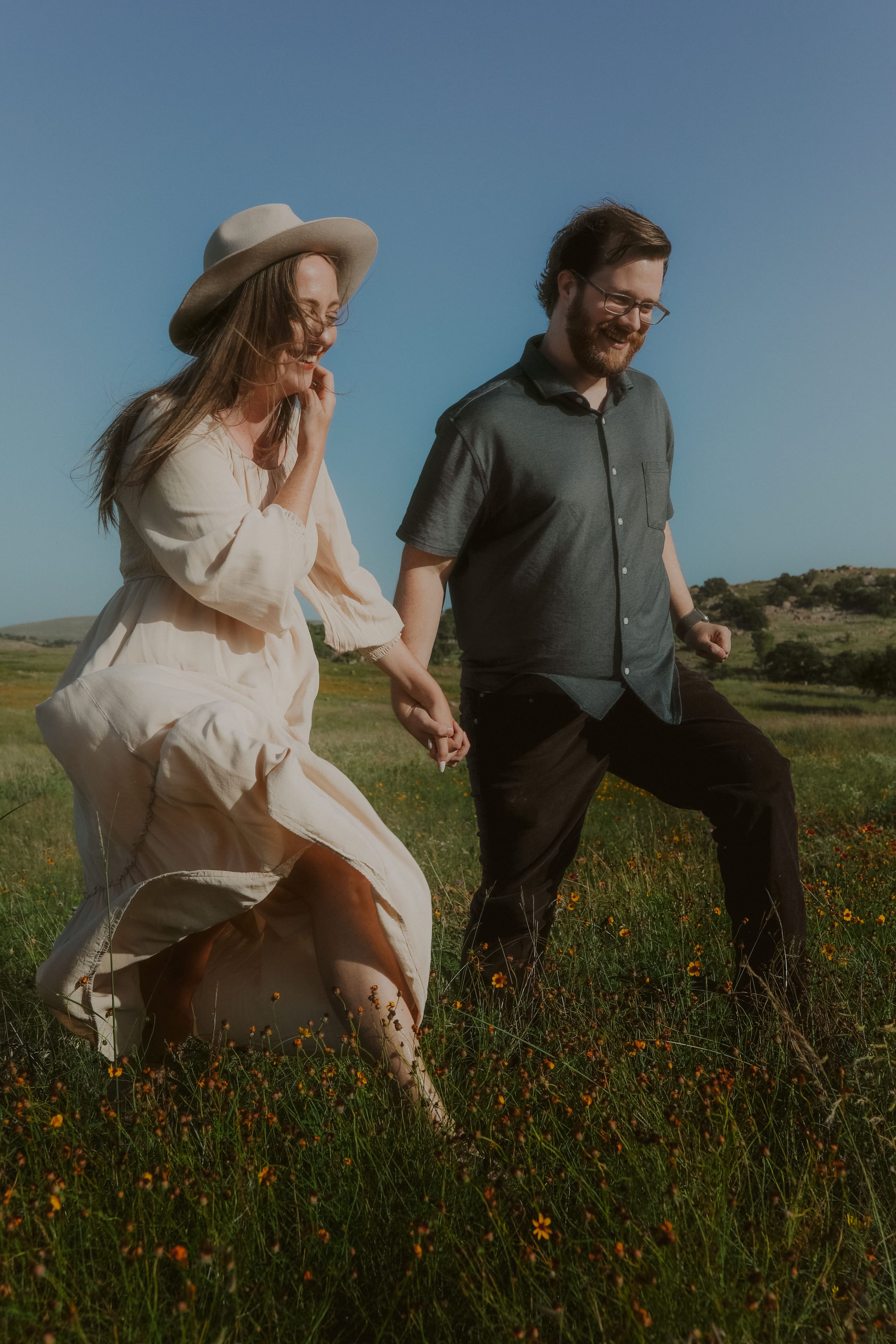Laughing through the wildflowers hand in hand under a clear sky