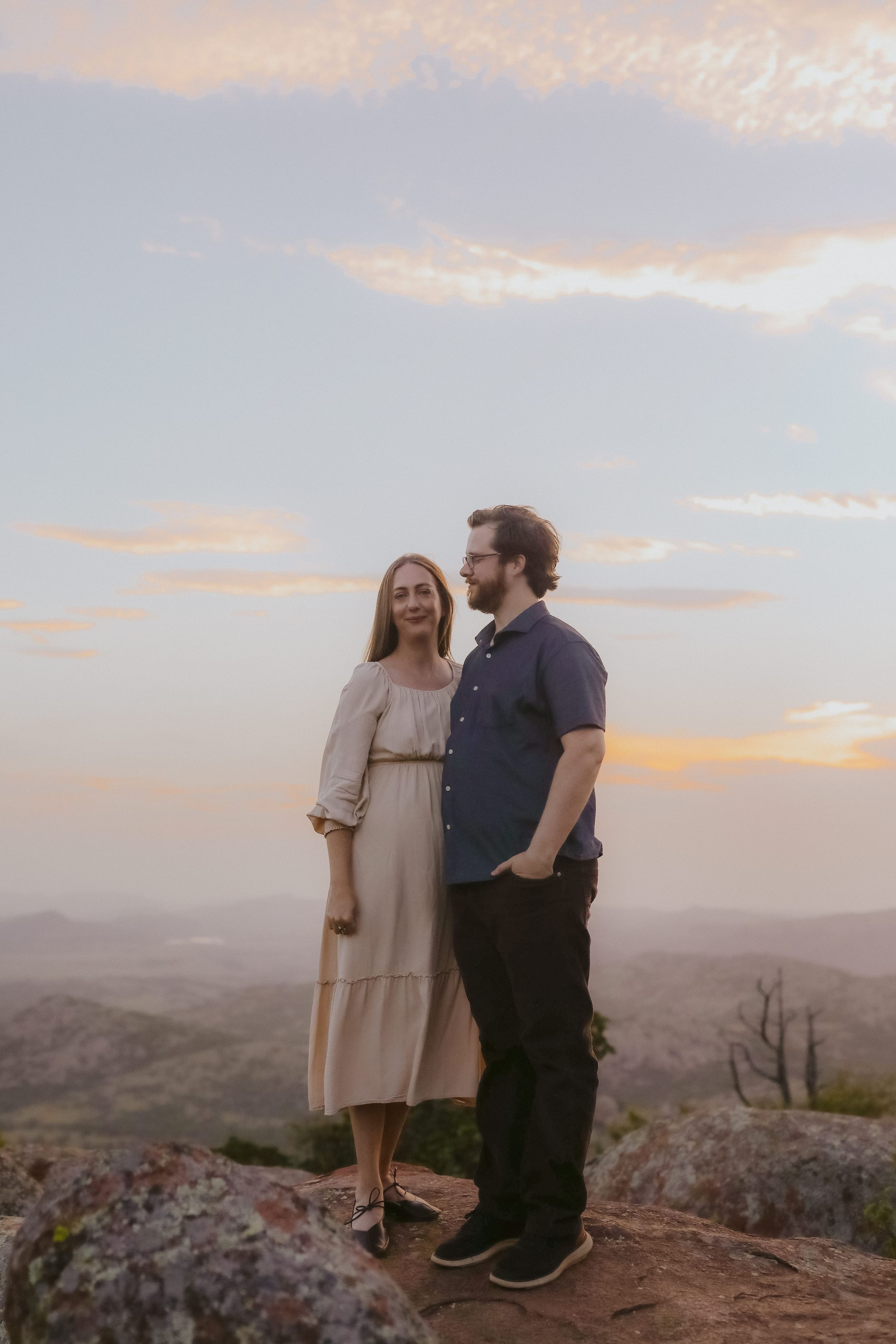 Standing together on the summit rocks as sunset colors the valley