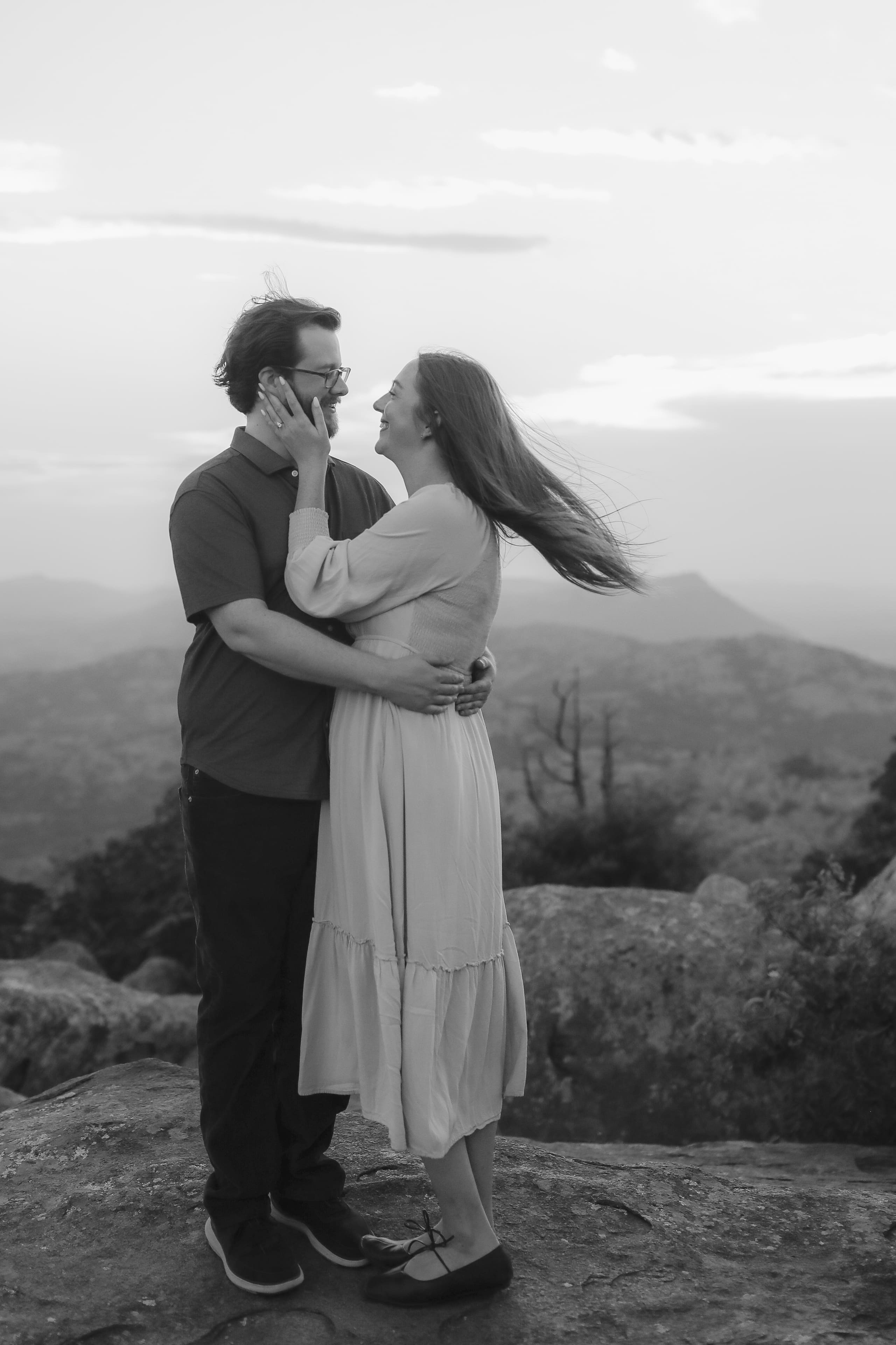 A black and white embrace on the mountaintop, wind in her hair