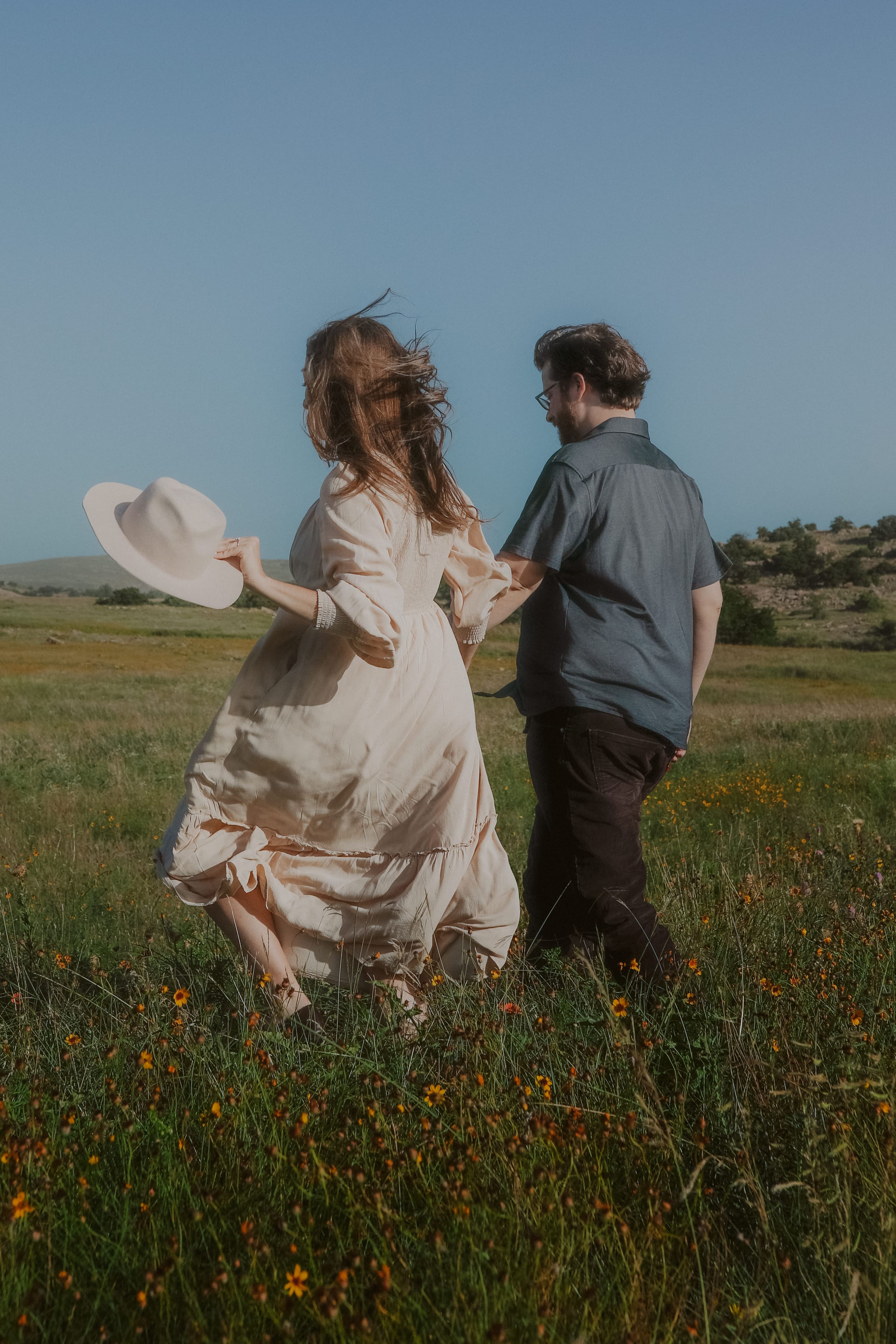 Walking through the wildflower field, hat in hand, hair in the wind