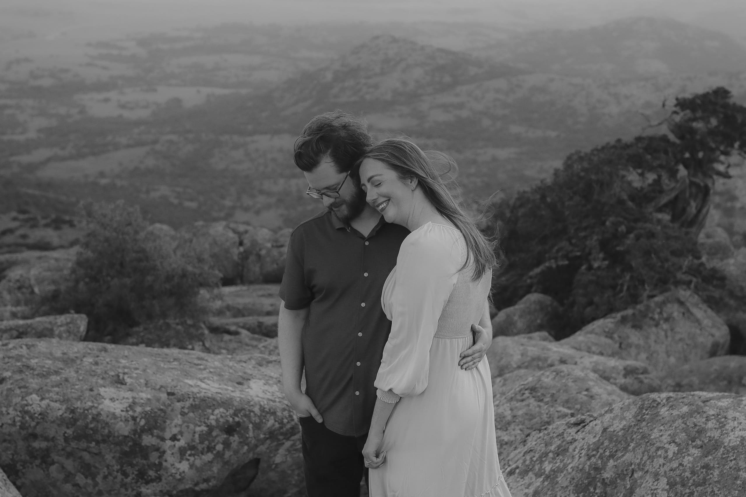 Her head tucked against his, smiling above the valley in black and white