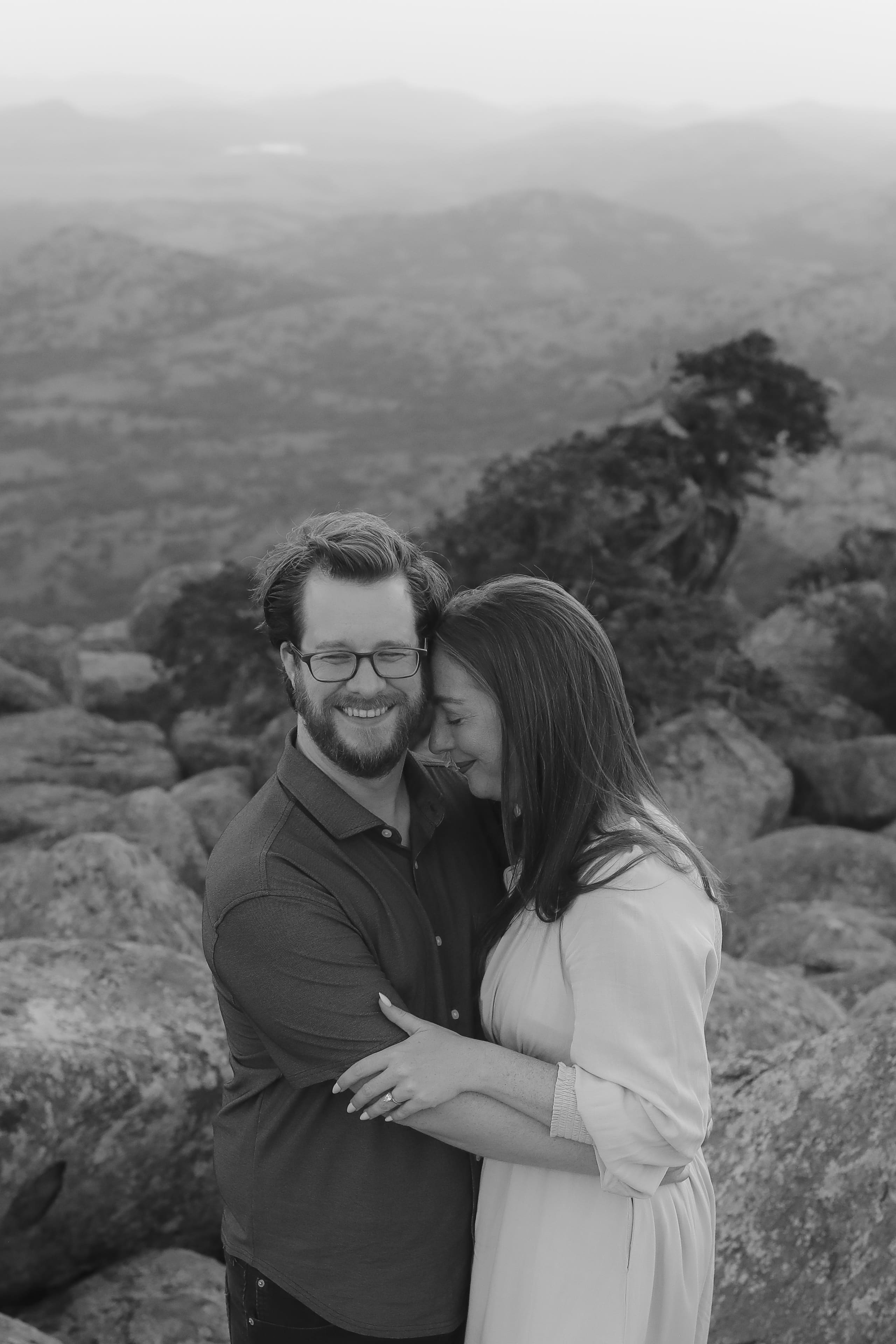 A black and white embrace on the peak, foreheads close, both smiling