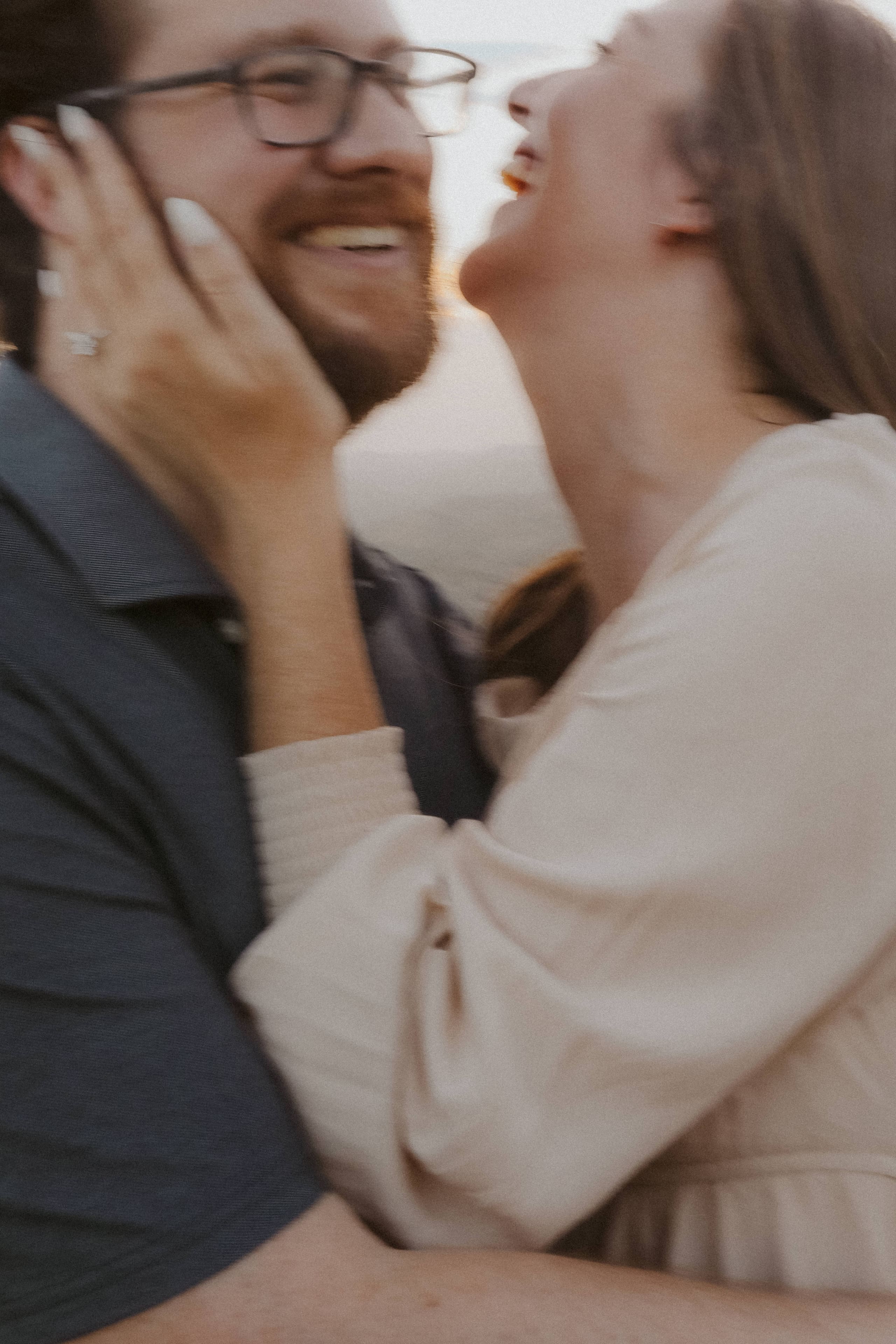 Laughing close together, her hand resting on his cheek
