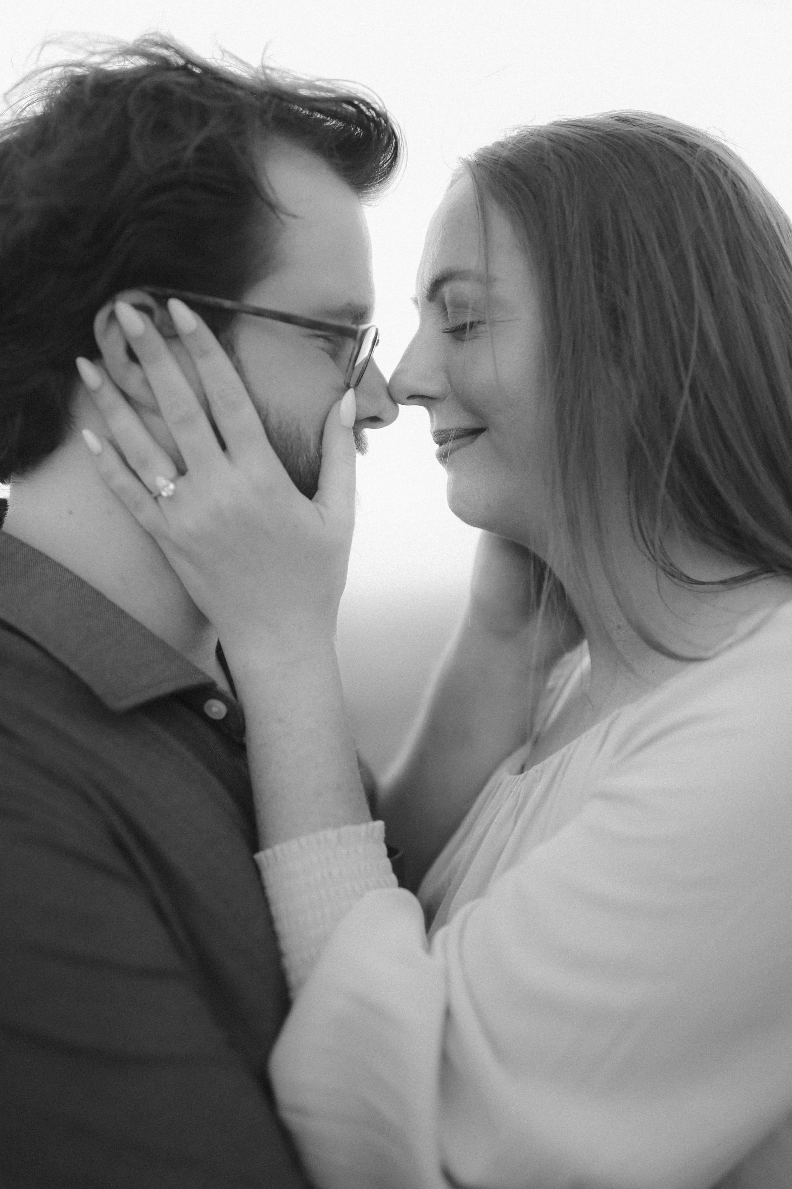 Forehead to forehead in black and white, her ring catching the light