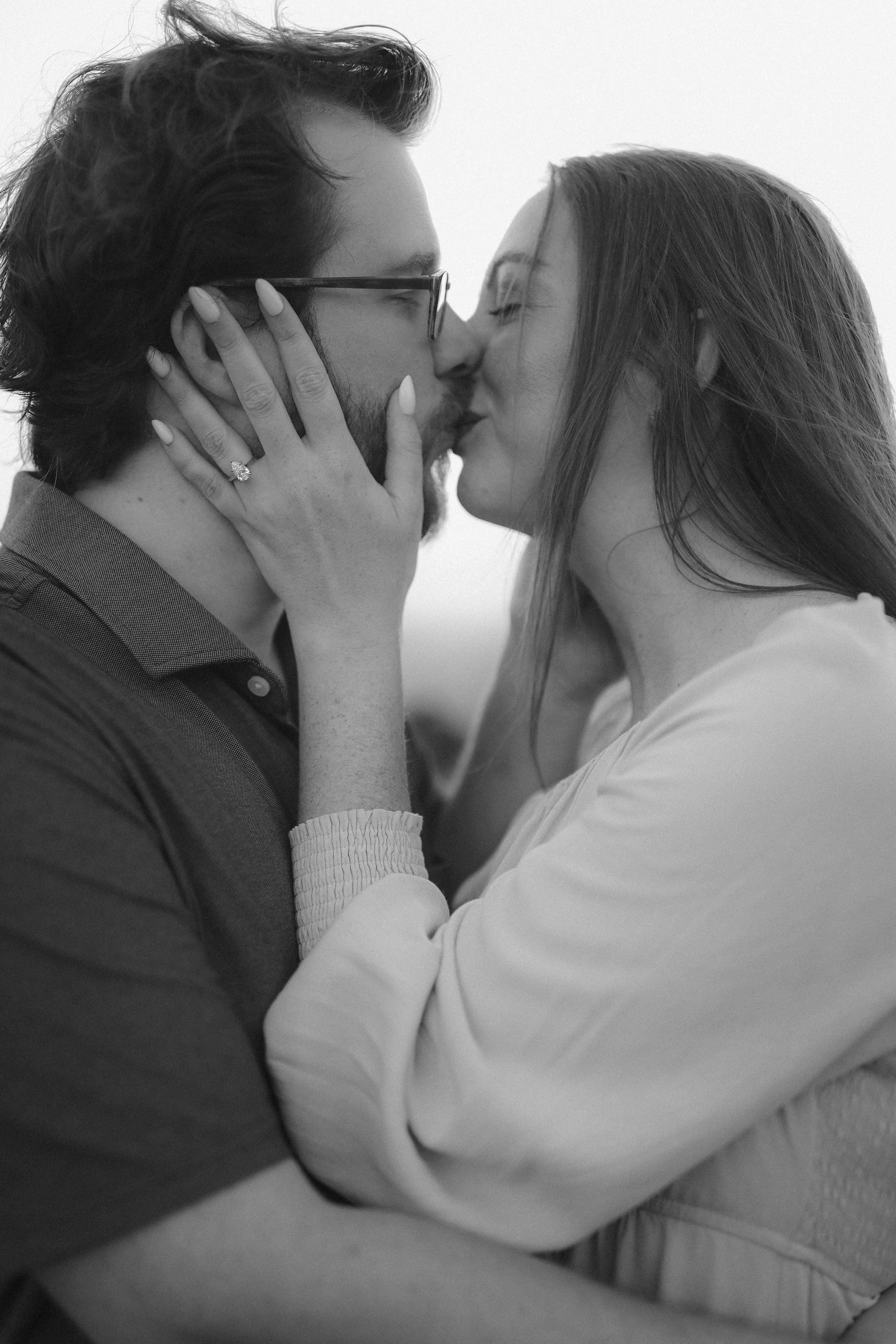 A quiet kiss in black and white, her hand against his cheek