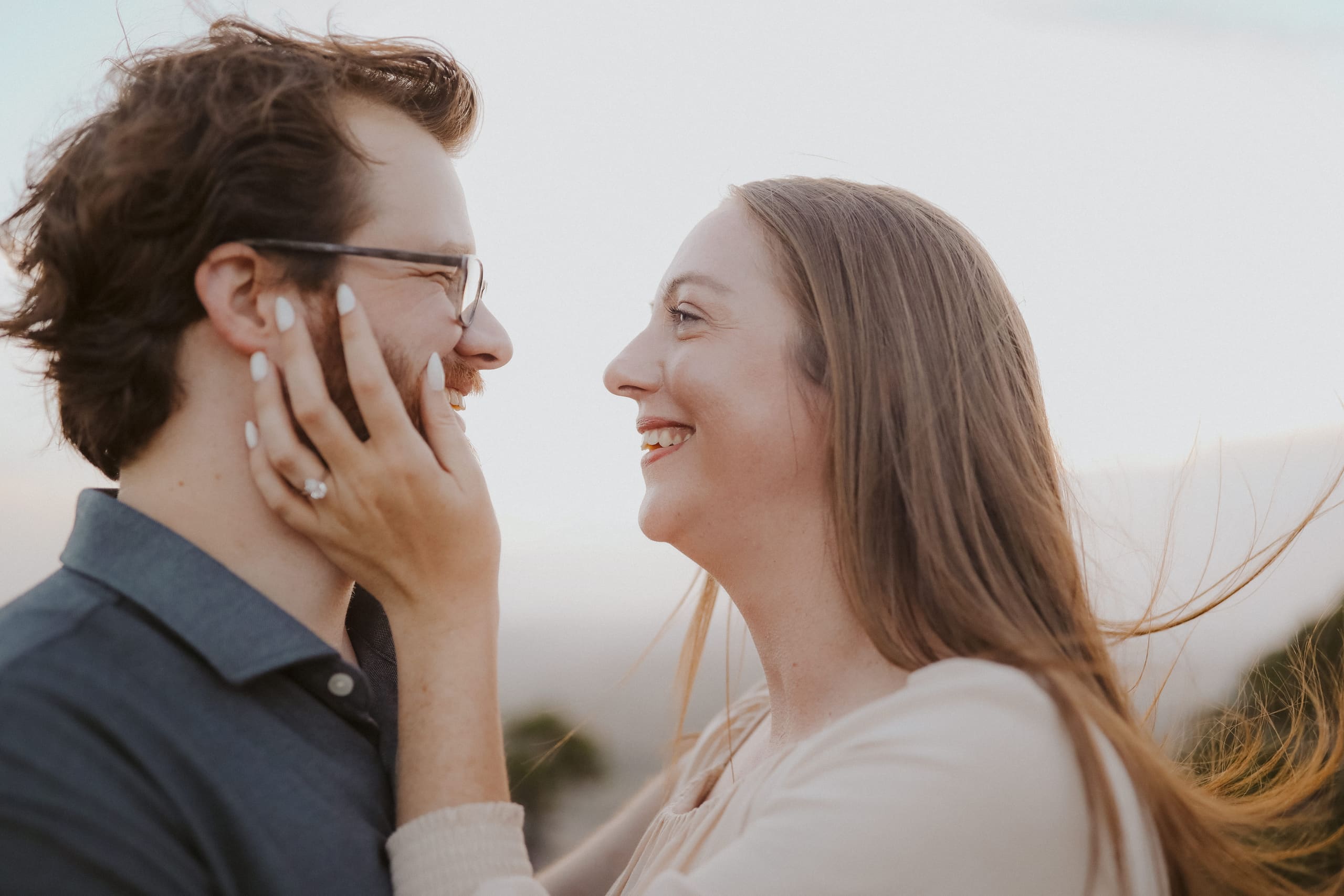 Face to face and laughing, hair caught in the breeze
