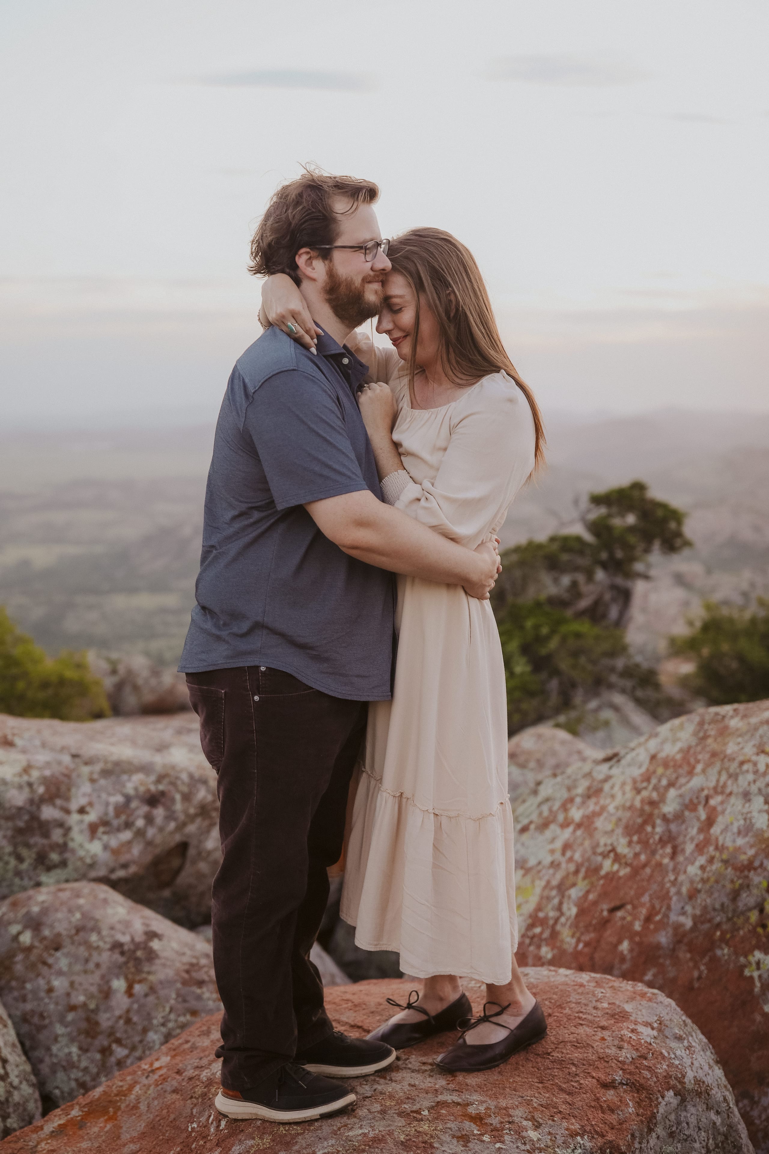 A quiet embrace on the mountaintop, the valley fading below