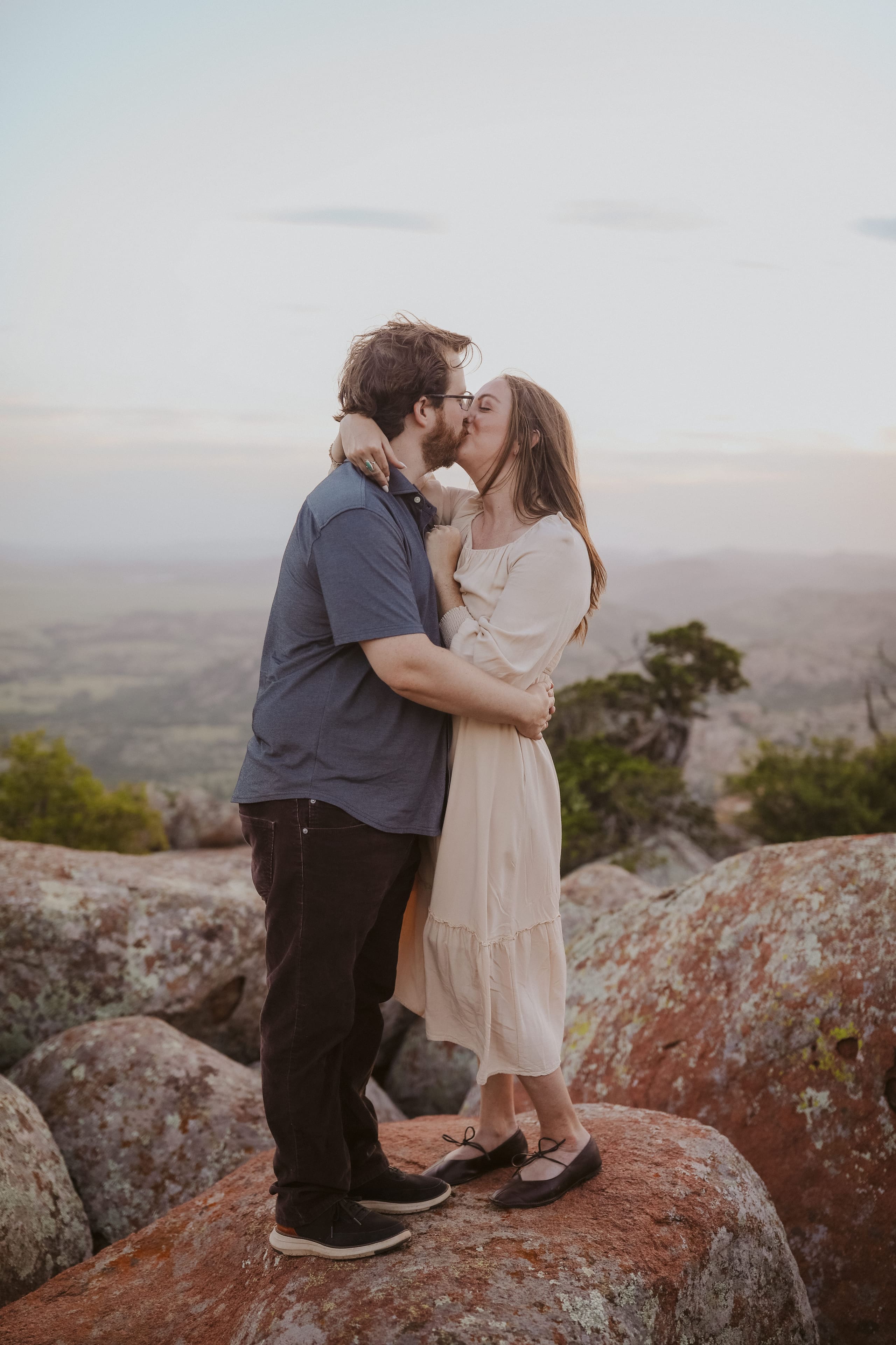 A kiss on the granite summit, valley stretching out behind