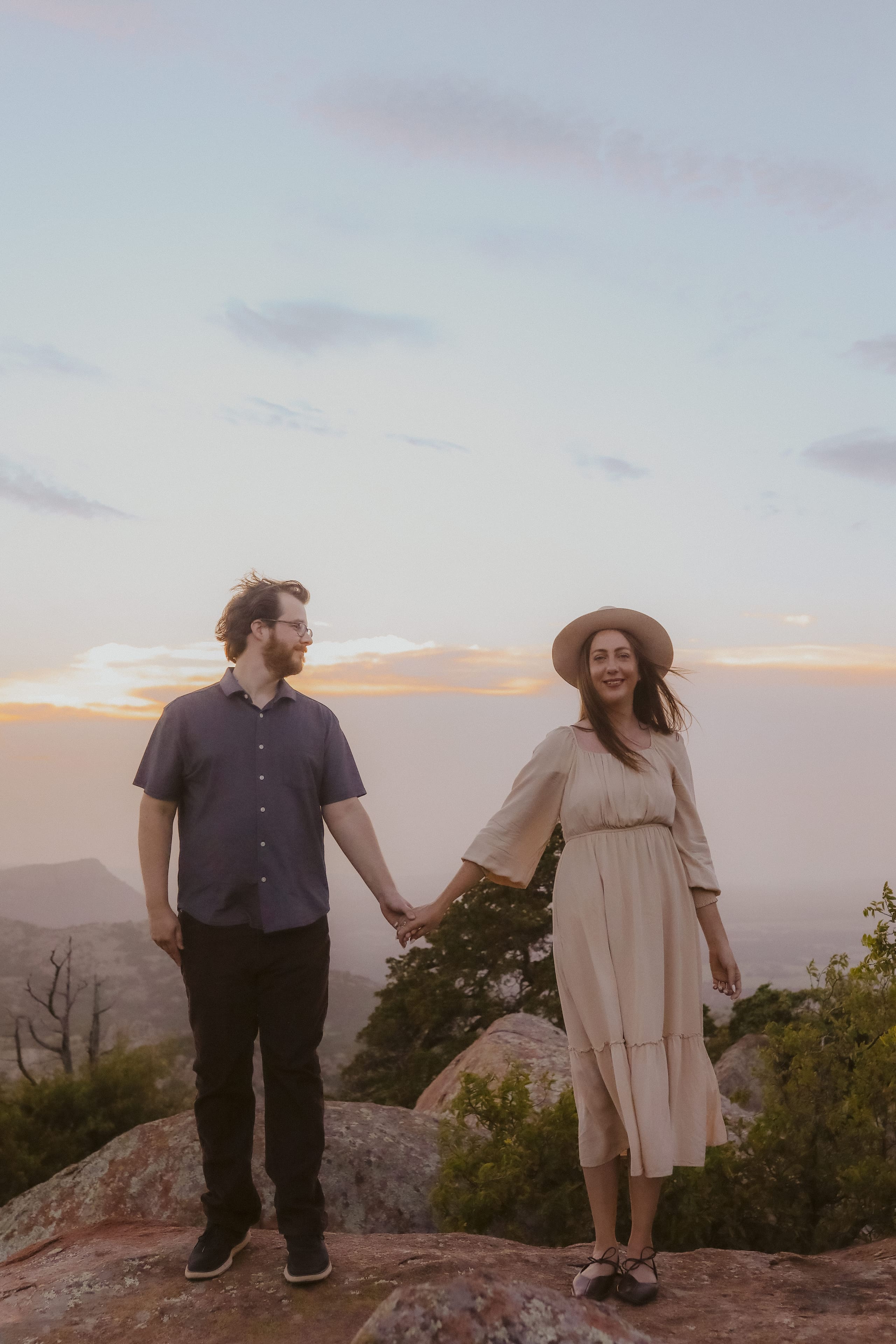 Hand in hand on the mountaintop as the sun slips behind the hills