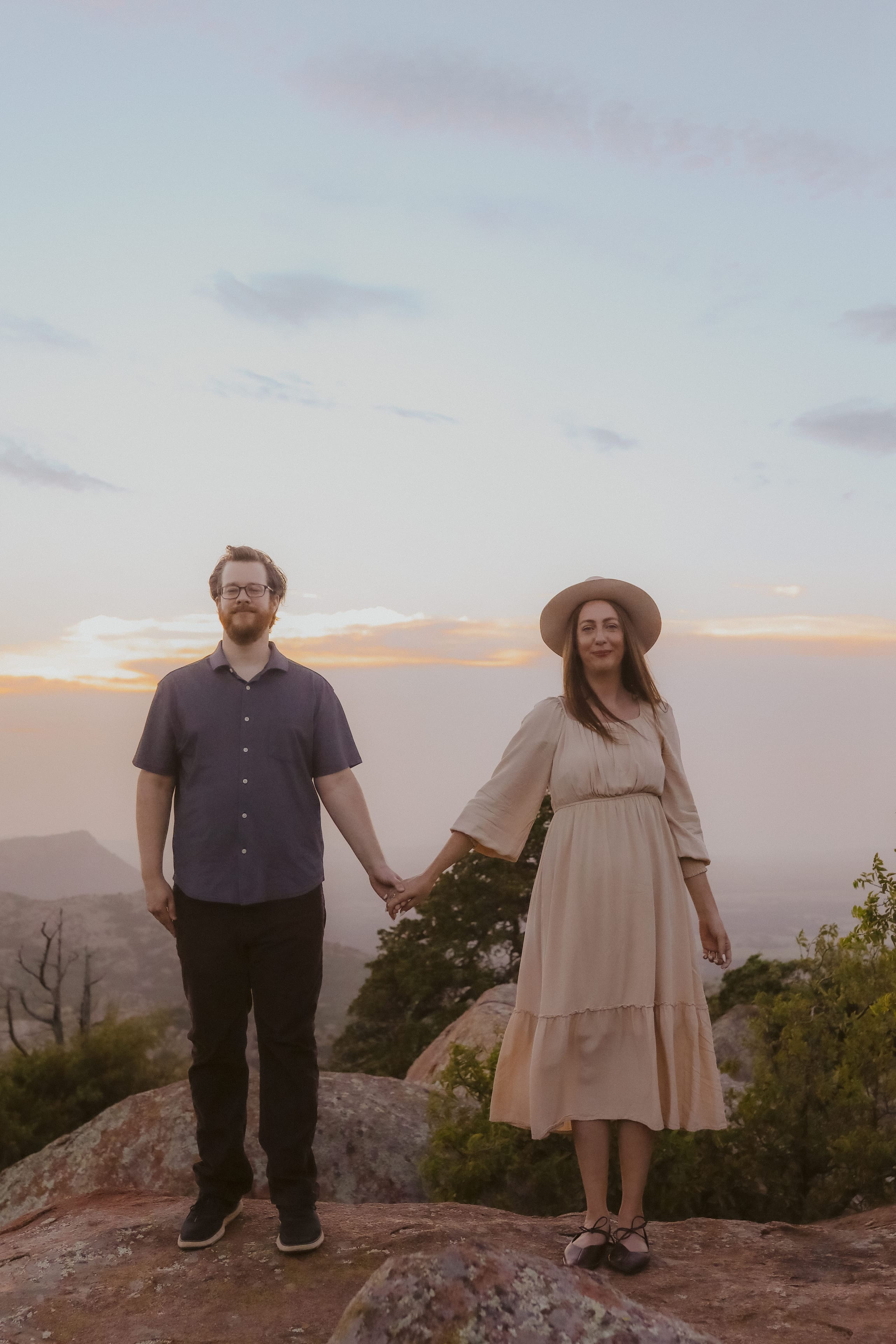 Side by side, hands joined, sunset clouds breaking behind them