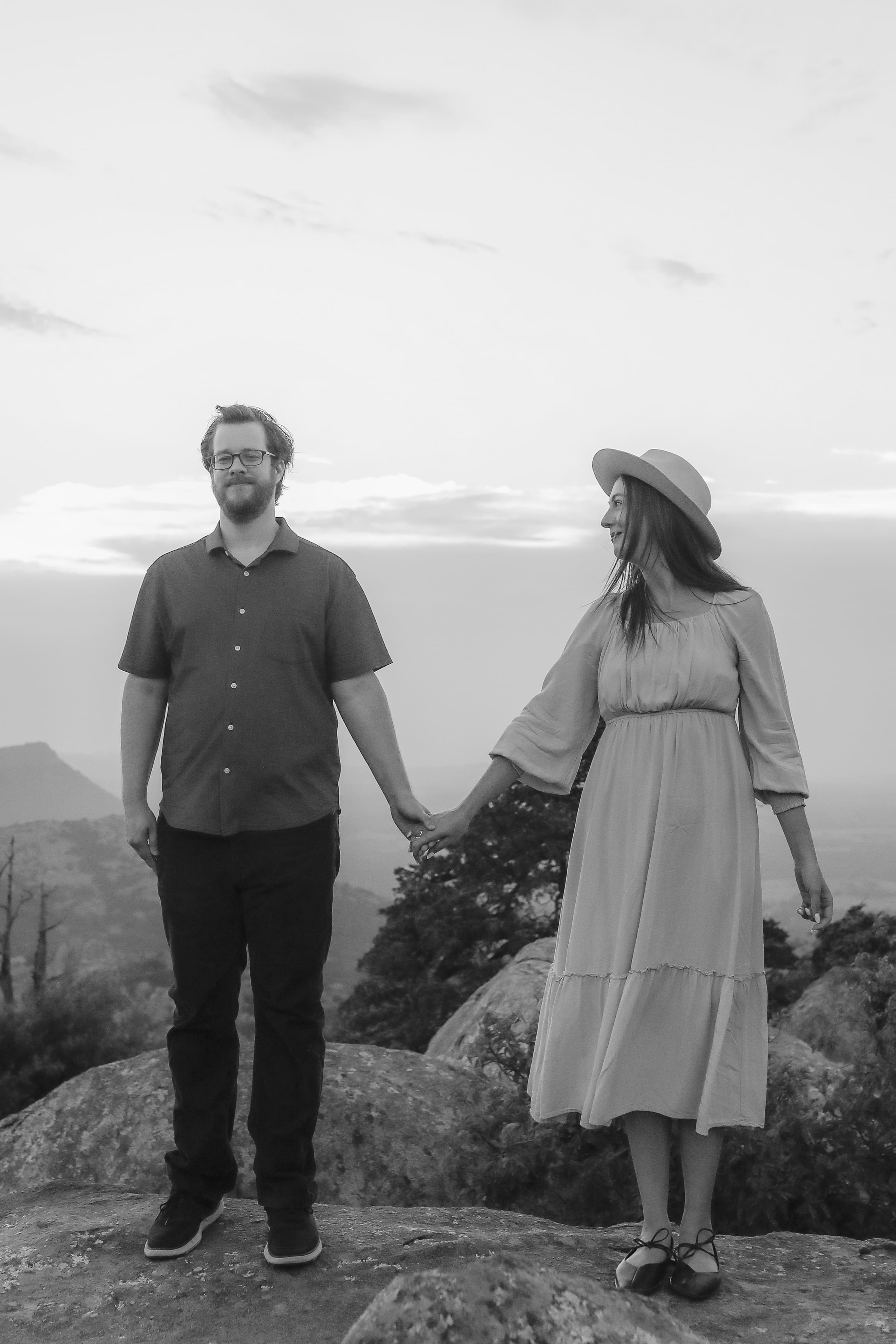 Holding hands on the summit, her gaze turned toward him