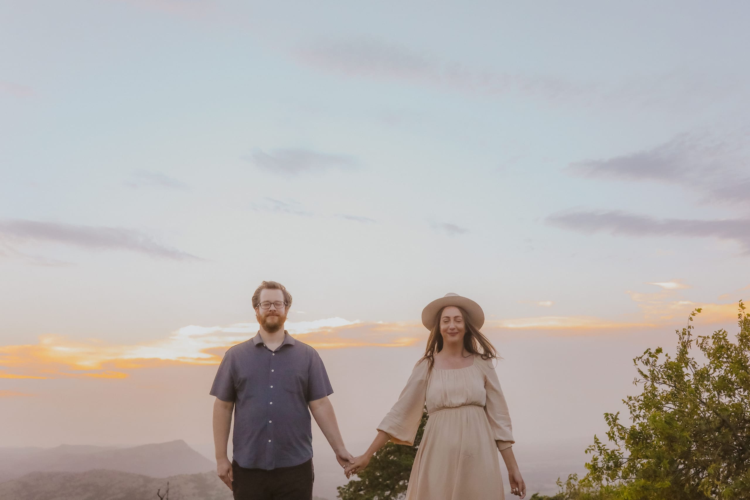 The couple at dusk on the summit, the valley fading below