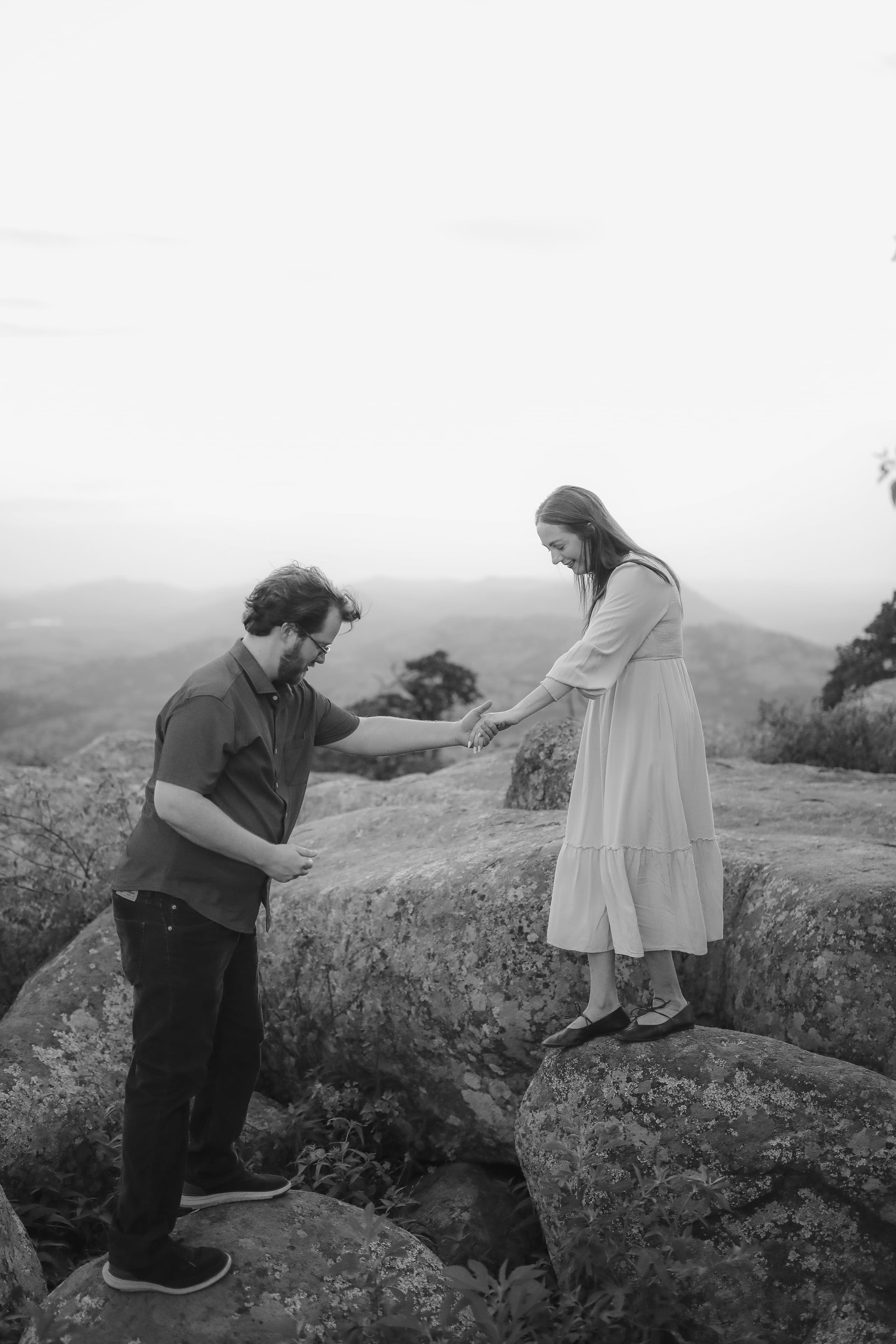 A steadying hand across the boulders, rendered in black and white