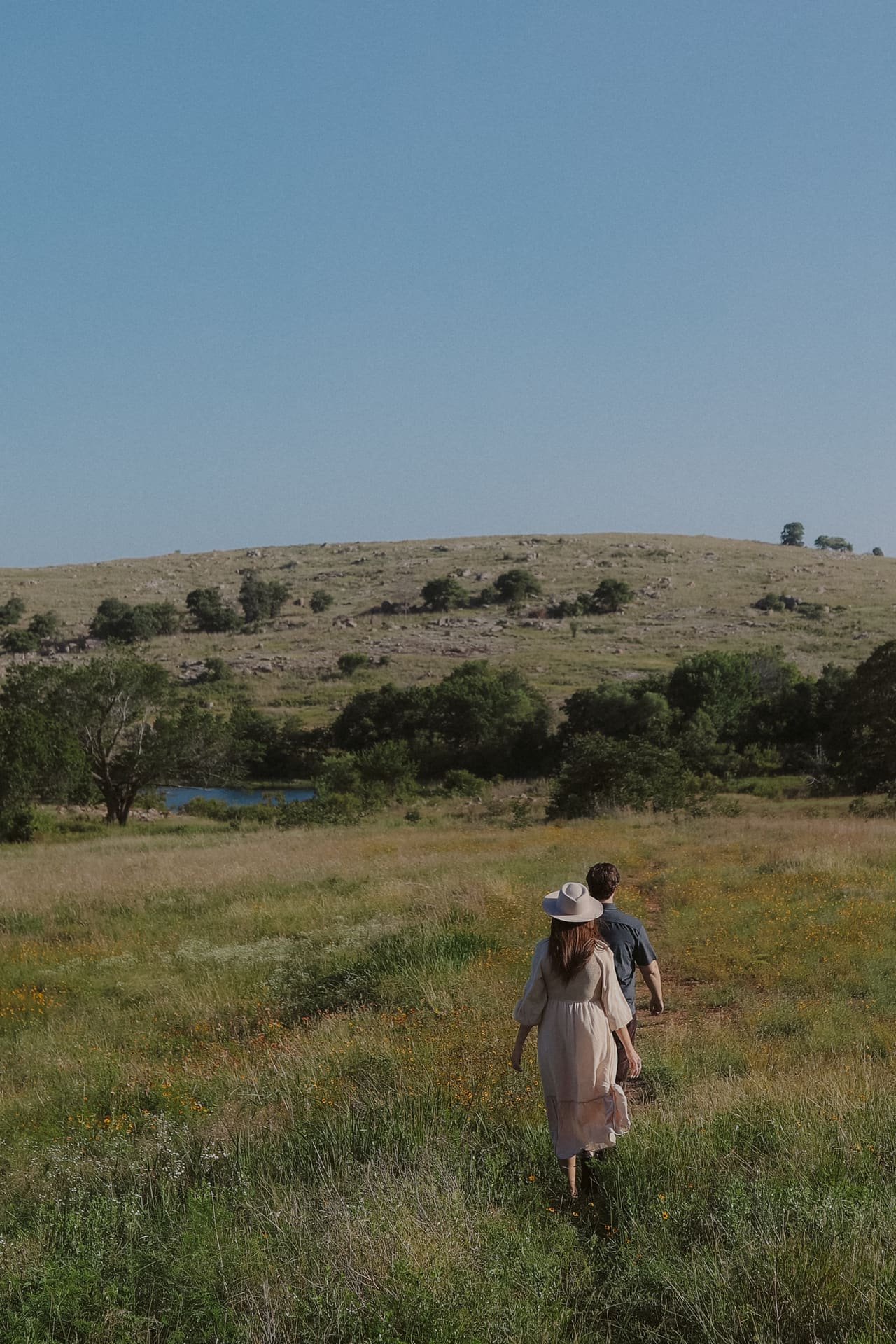 Walking a meadow path toward the pond, hills rising beyond