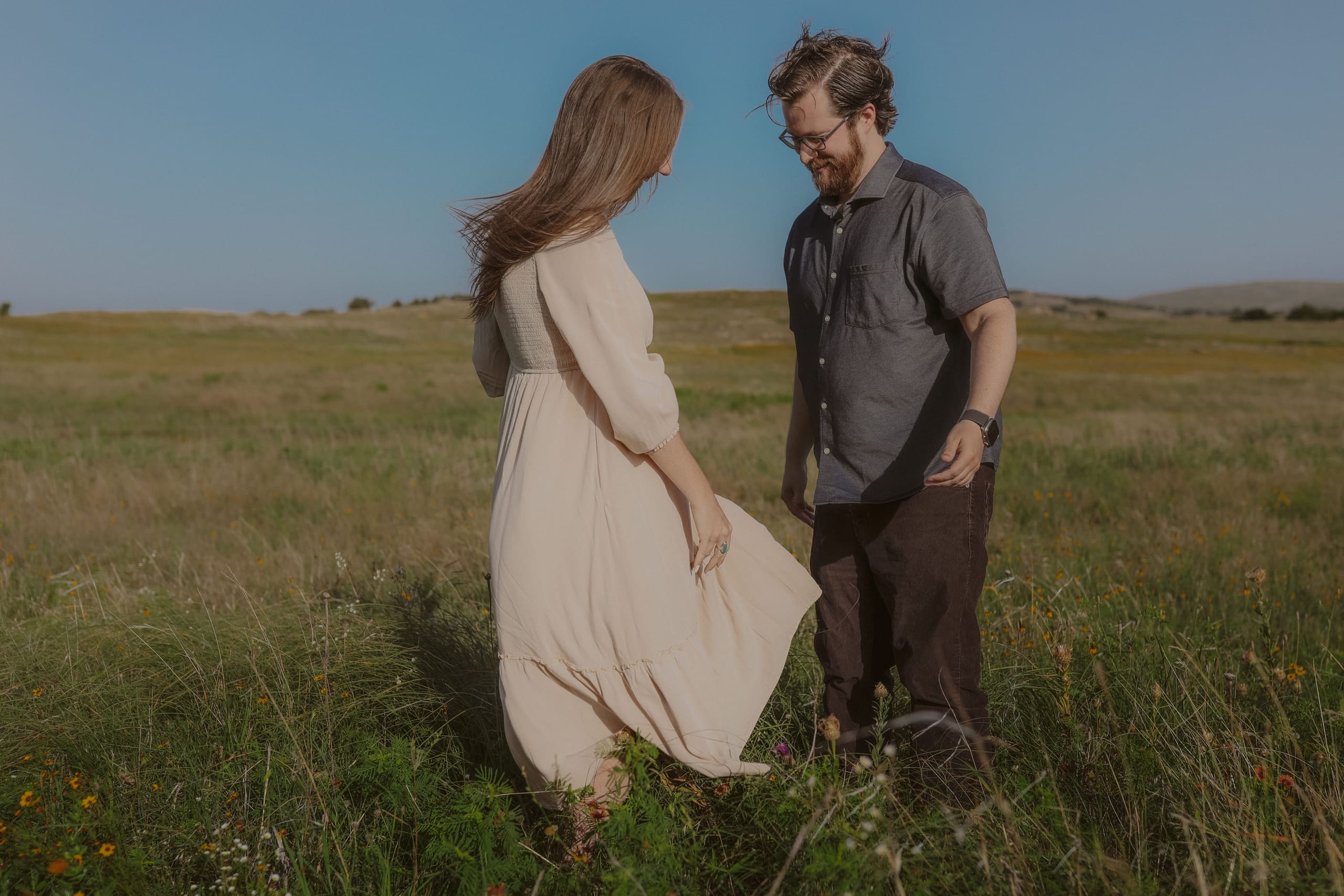 Heads bowed over the wildflowers, her dress gathered in one hand