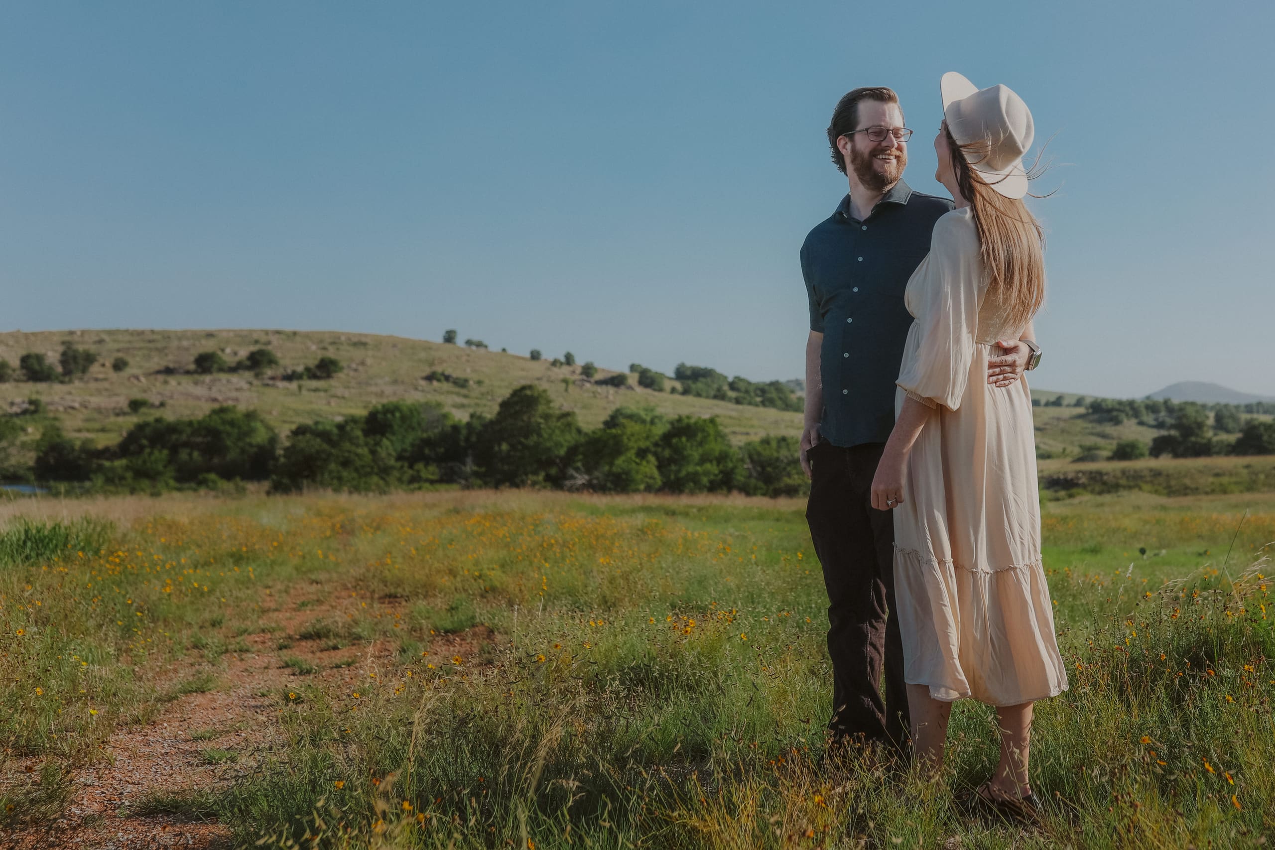 Smiling at each other on a sunlit path through the wildflowers