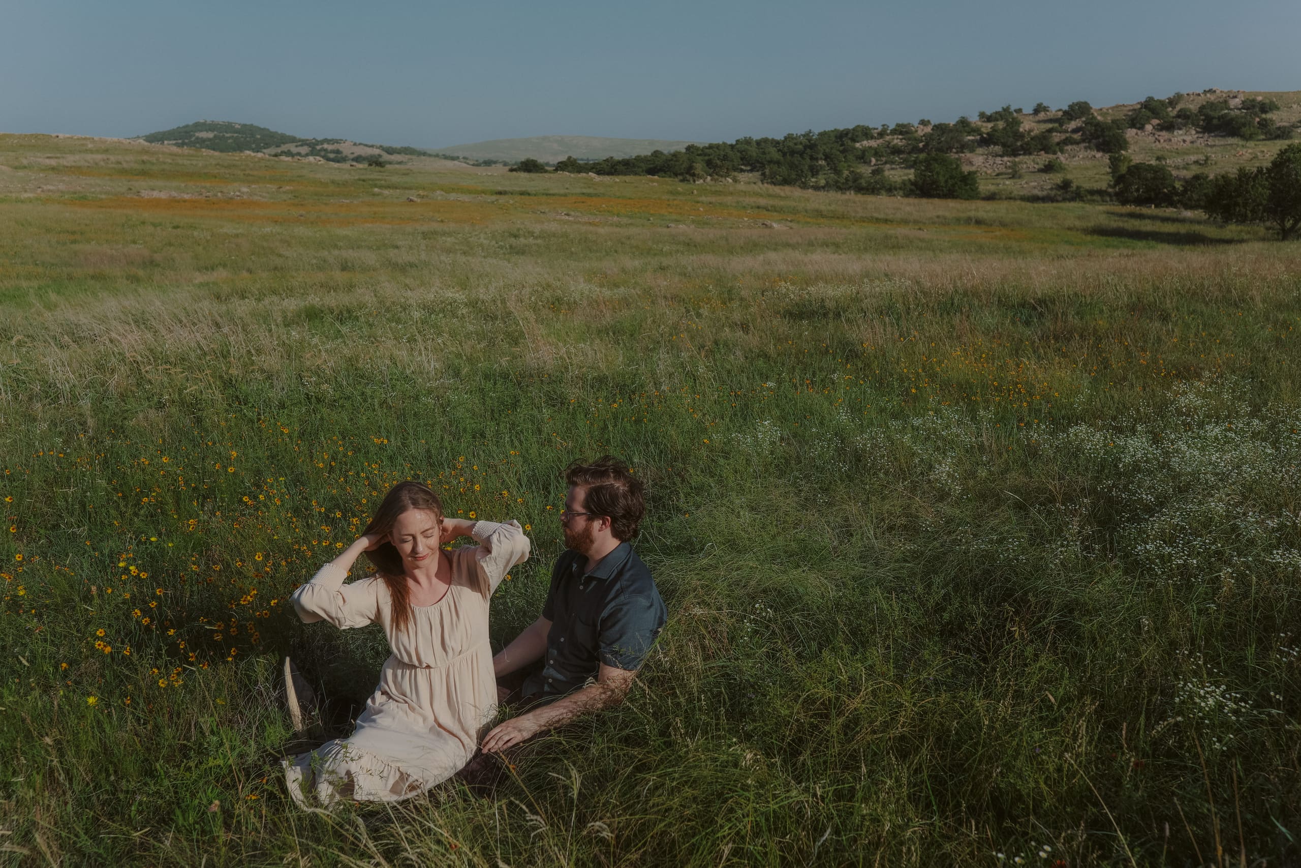 Settled together in tall grass, wildflowers scattered across the open prairie