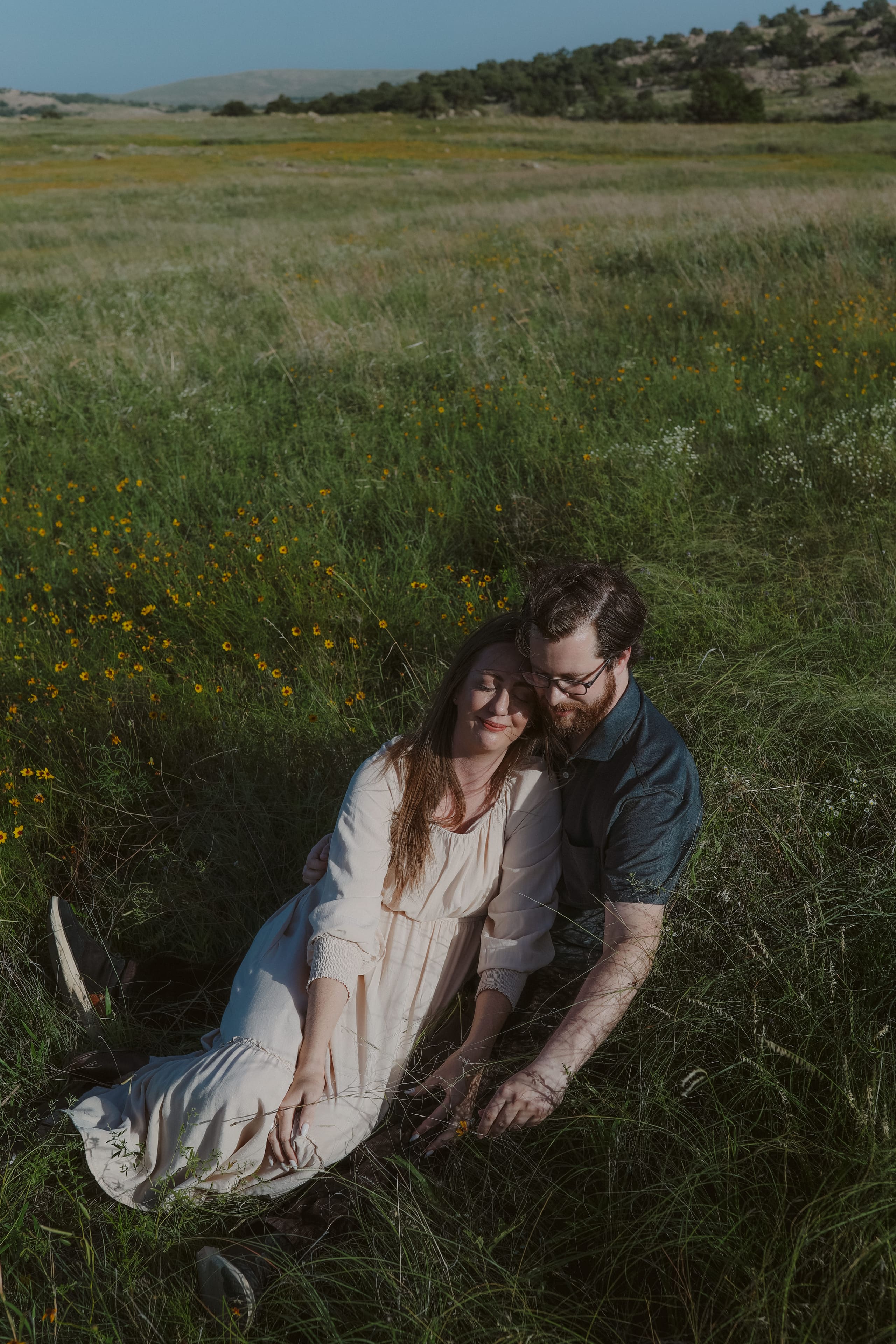 Her head resting against his in a field of yellow wildflowers