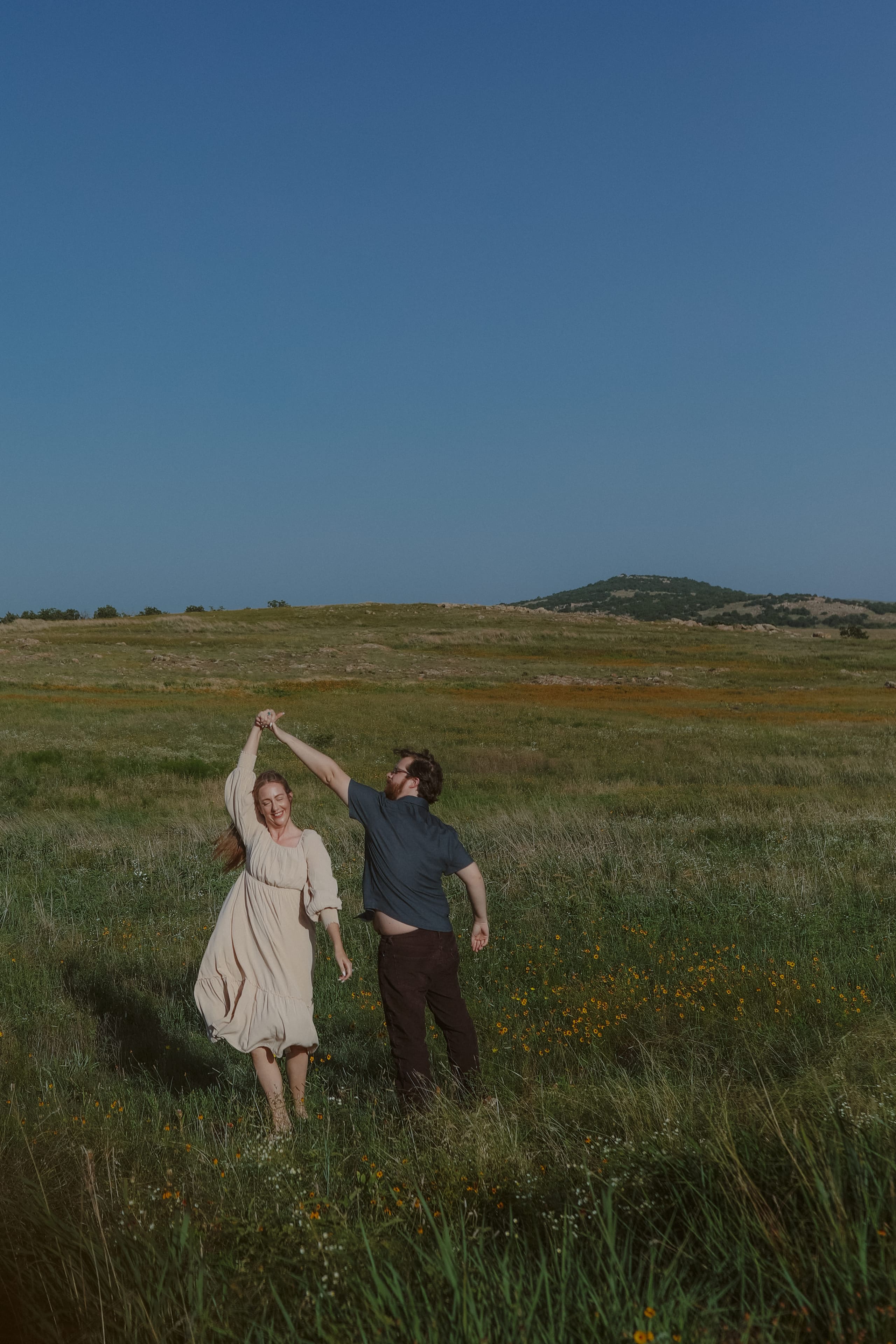 A twirl in the field, her arm raised in his hand