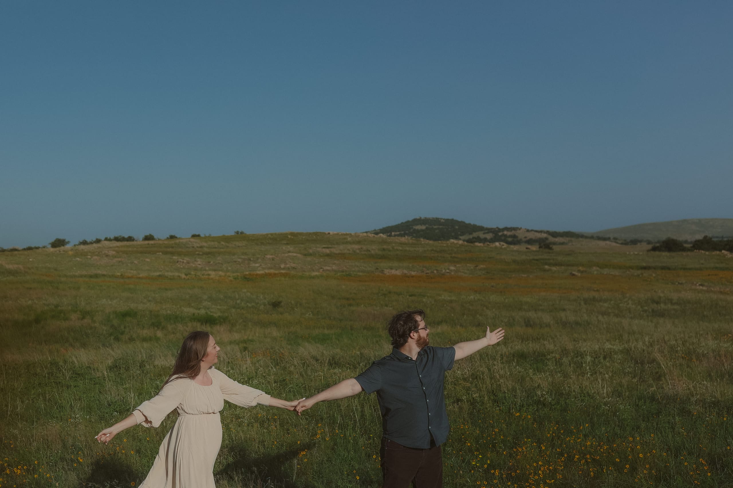 Arms outstretched, pulling each other along through the wildflowers