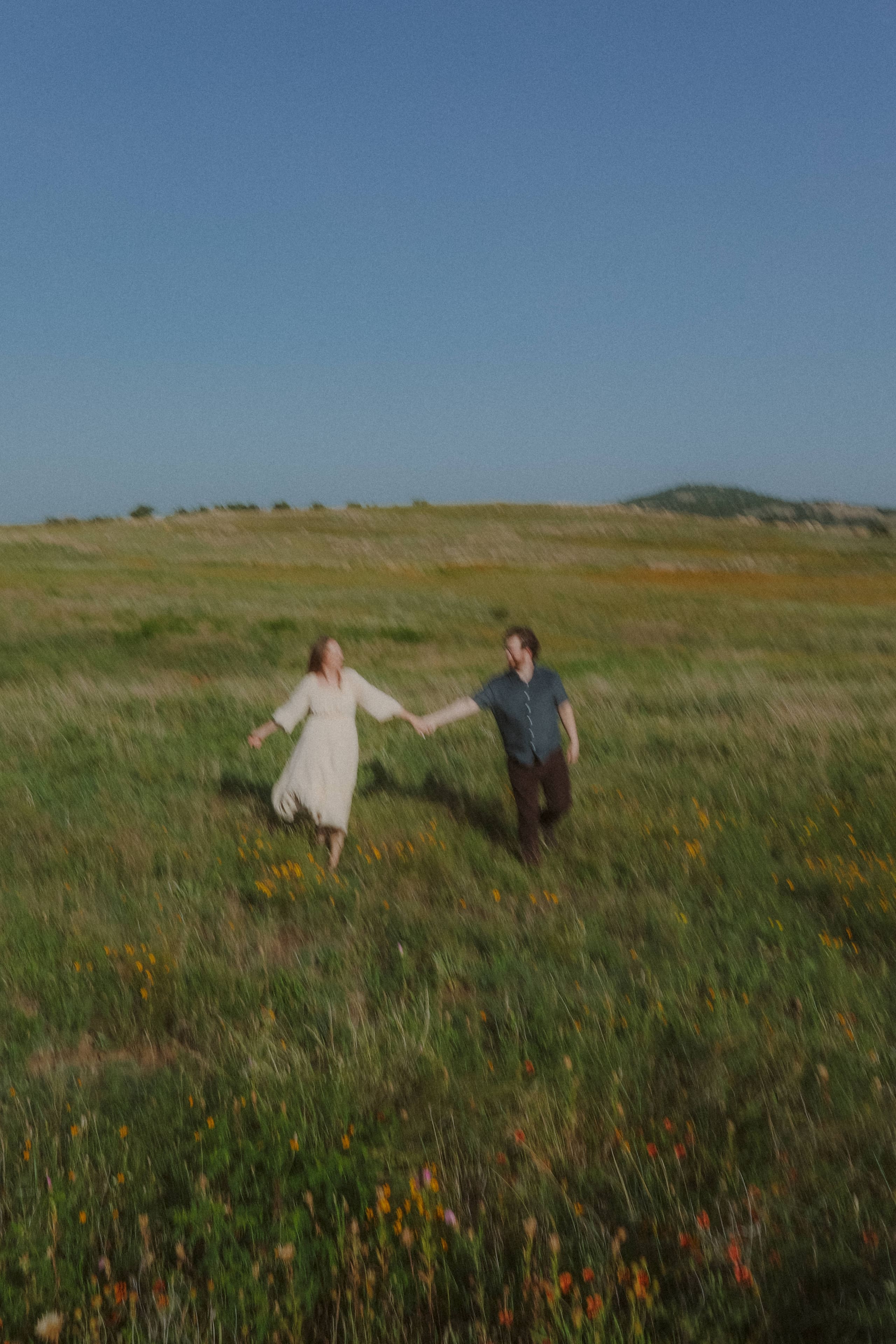 A soft-focus run through the field, hand in hand among the wildflowers