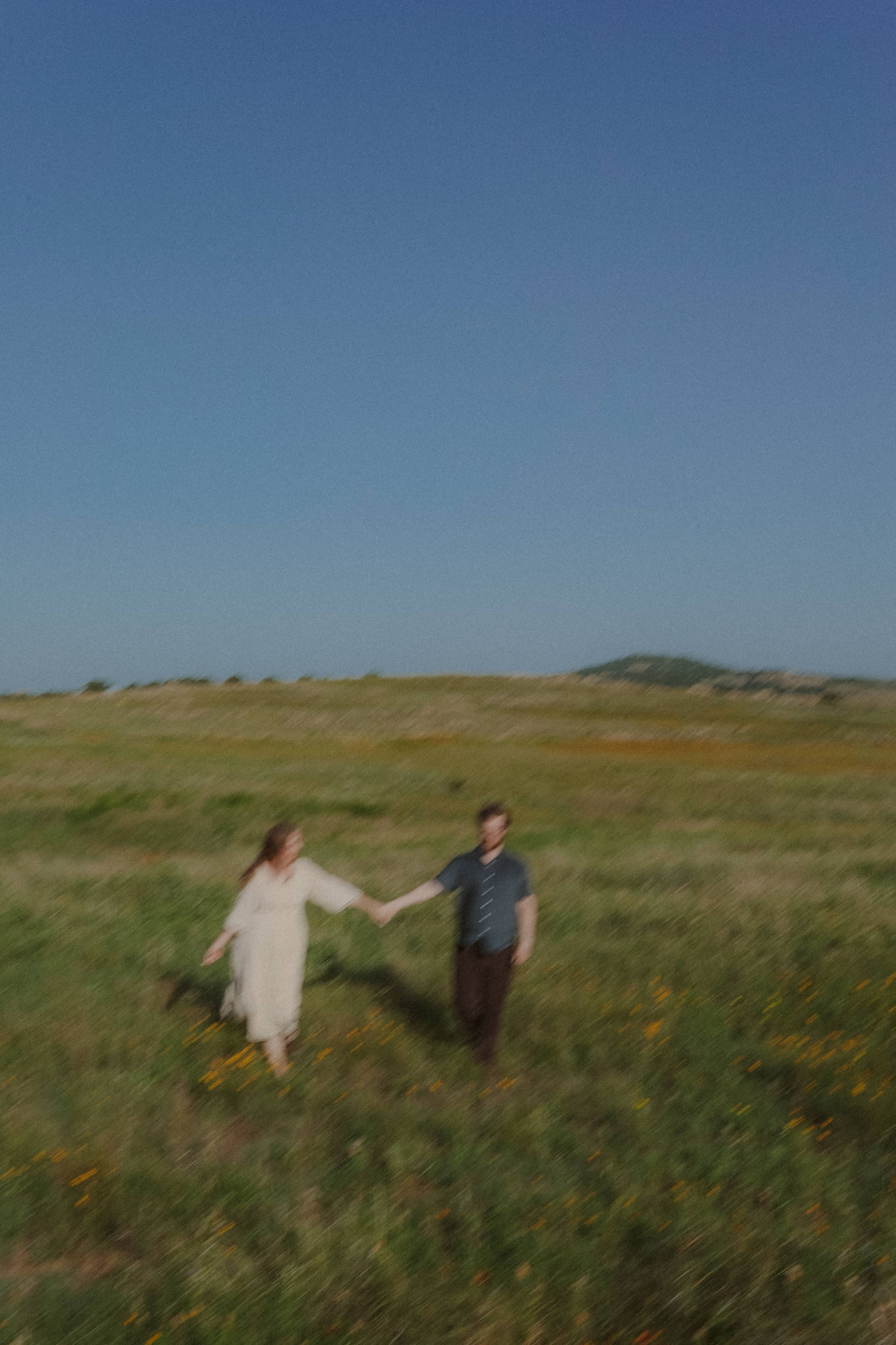 A soft motion blur — walking hand in hand across the open prairie