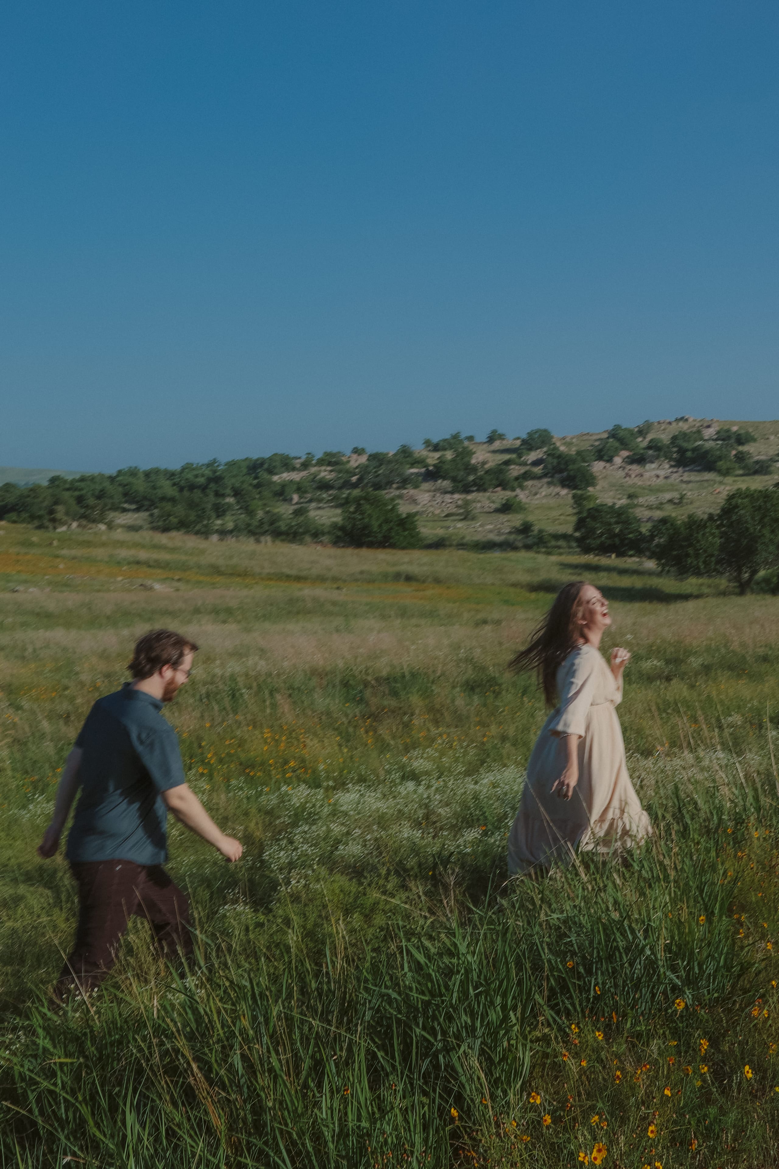She leads the way through the tall grass, laughing mid-stride