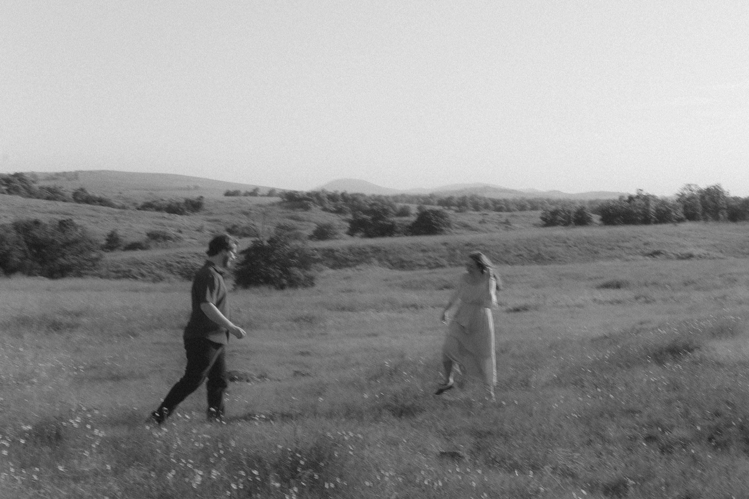 A black-and-white stroll across the open prairie, hills rolling behind