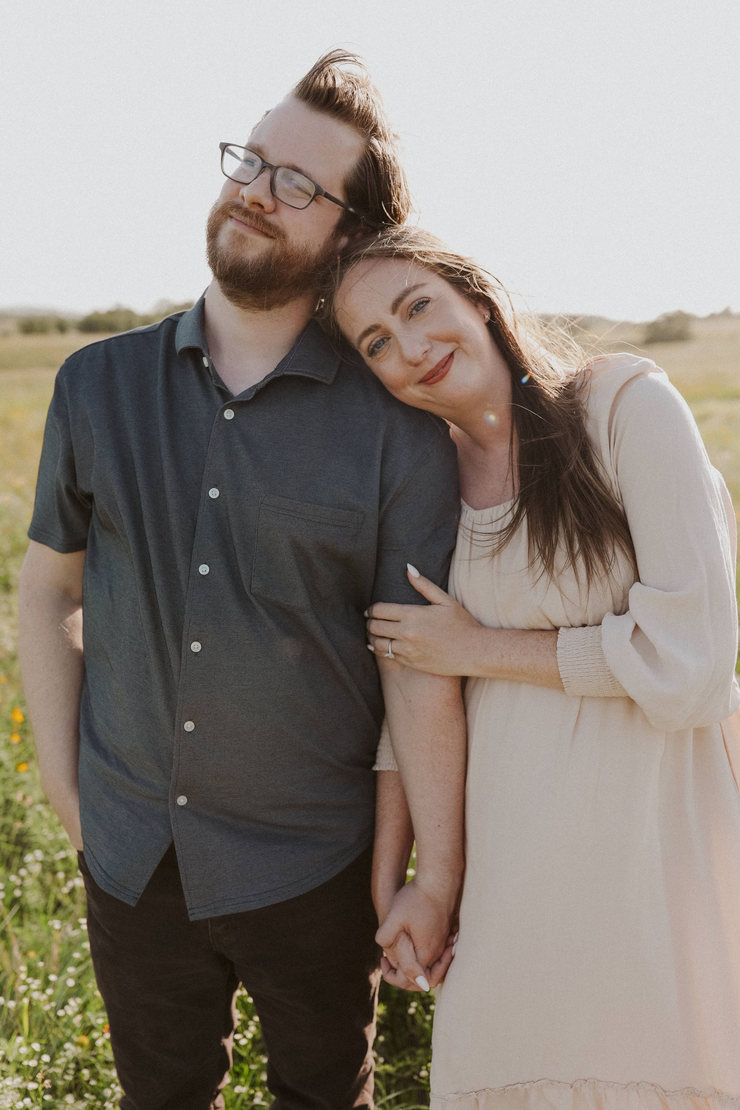 A quiet portrait — her head resting on his shoulder in golden light