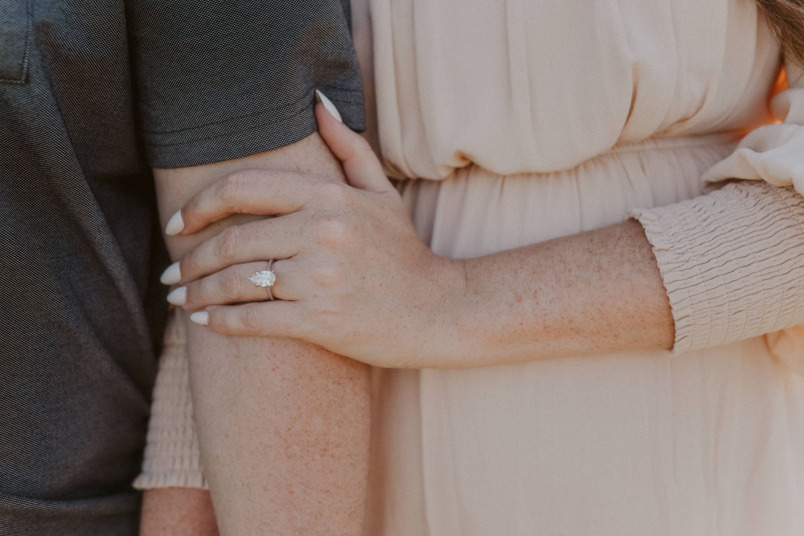 A close view of her ring, arms wrapped together